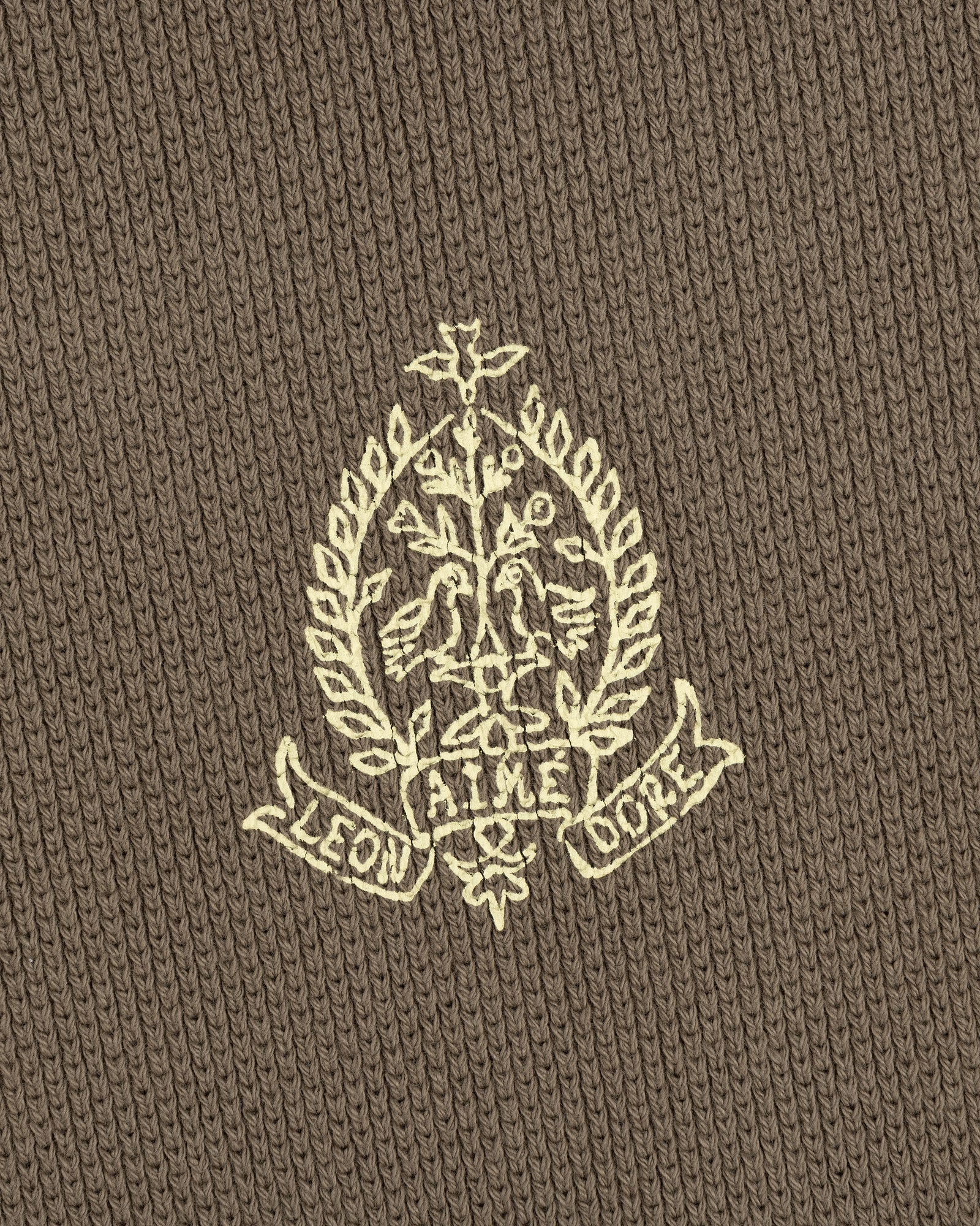 Embroidered crest with leaves and "LEON AIME COPE" on brown Saint George Piqué Crewneck Sweatshirt.