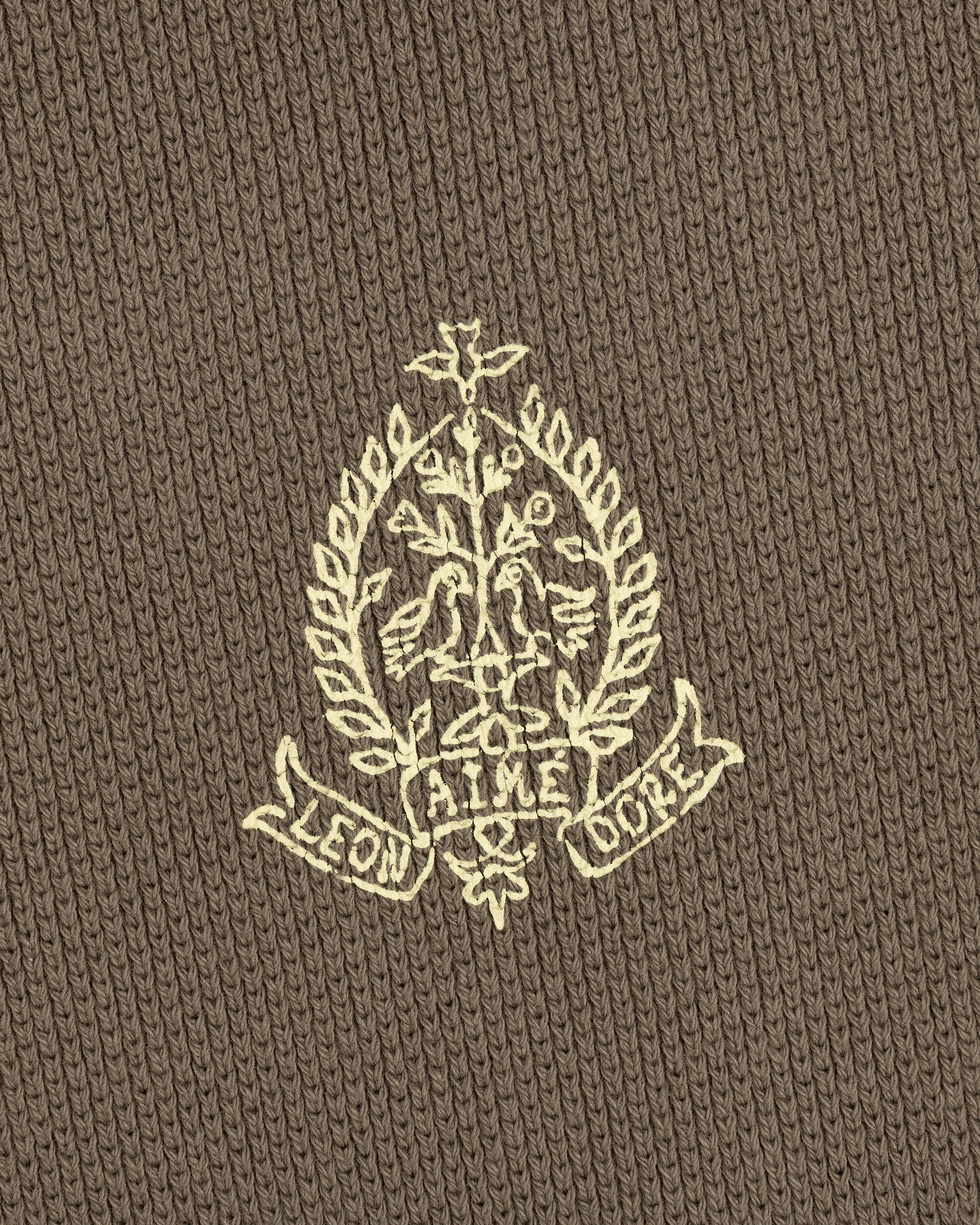 Embroidered crest with leaves and "LEON AIME COPE" on brown Saint George Piqué Crewneck Sweatshirt.