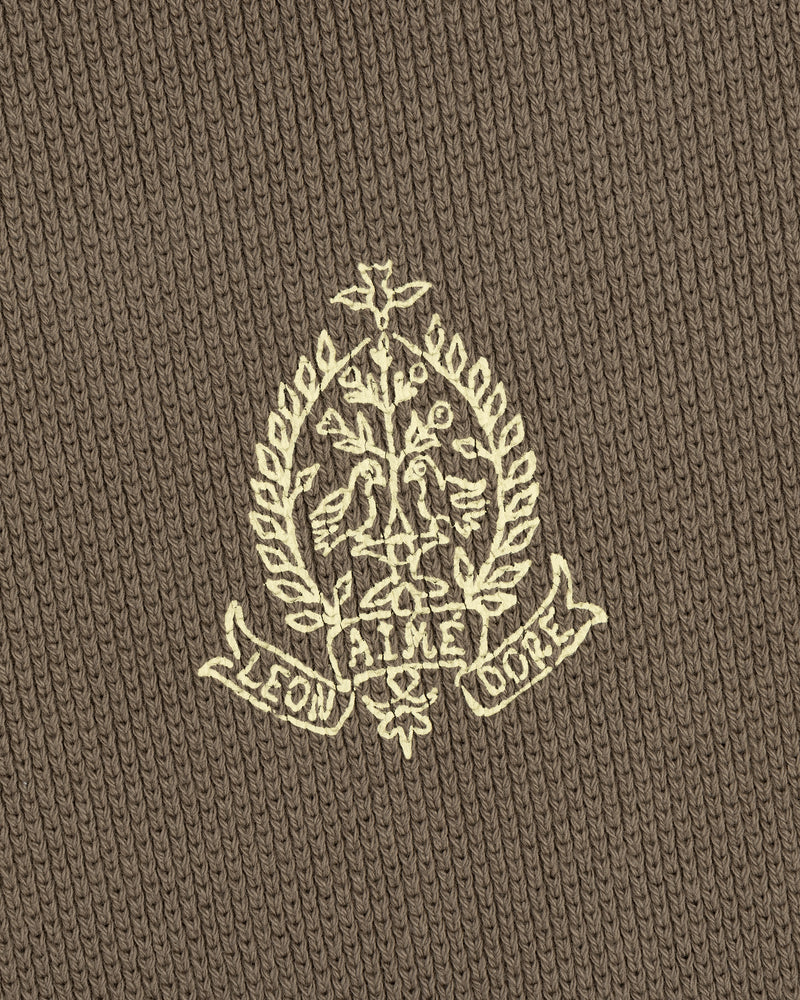 Embroidered crest with leaves and "LEON AIME COPE" on brown Saint George Piqué Crewneck Sweatshirt.