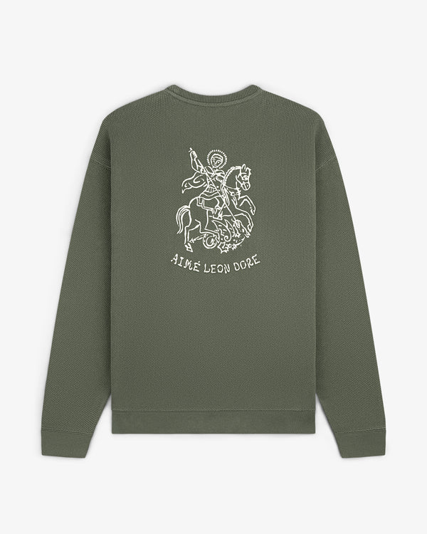 Saint George Piqué Crewneck Sweatshirt in olive with a knight graphic and AIMÉ LEON DORE text on the back.