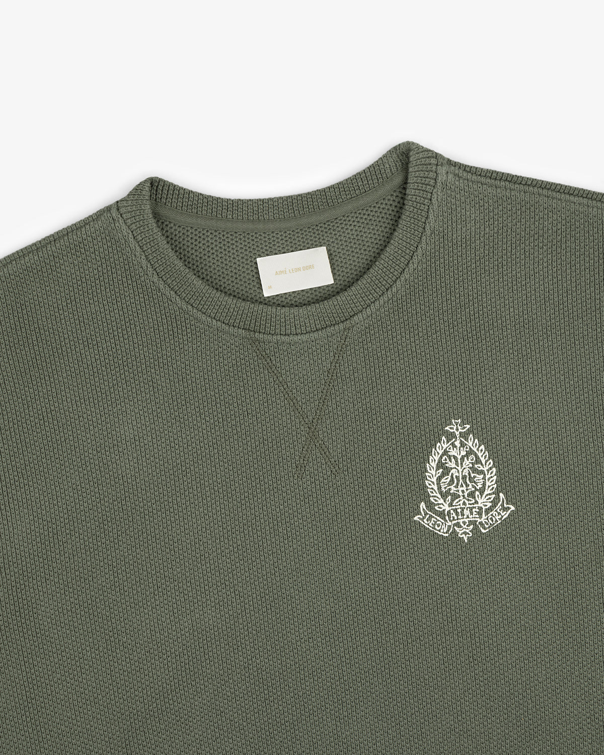Saint George Piqué Crewneck Sweatshirt in olive with white embroidered crest on chest and visible neck label.