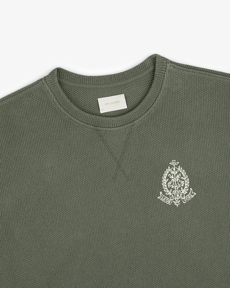 Saint George Piqué Crewneck Sweatshirt in olive with white embroidered crest on chest and visible neck label.