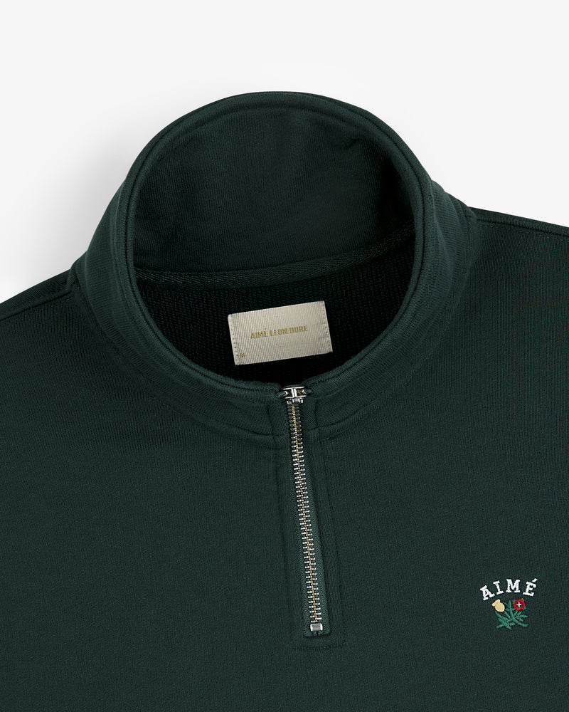 Dark green Crest Quarter Zip Pullover with AIMÉ and rose embroidery on the chest.