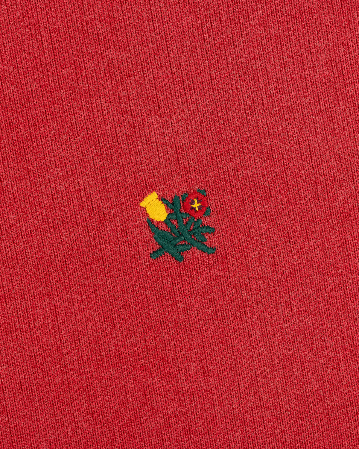 Yellow and red flower embroidery on Sun Faded Crest Quarter Zip's red fabric.