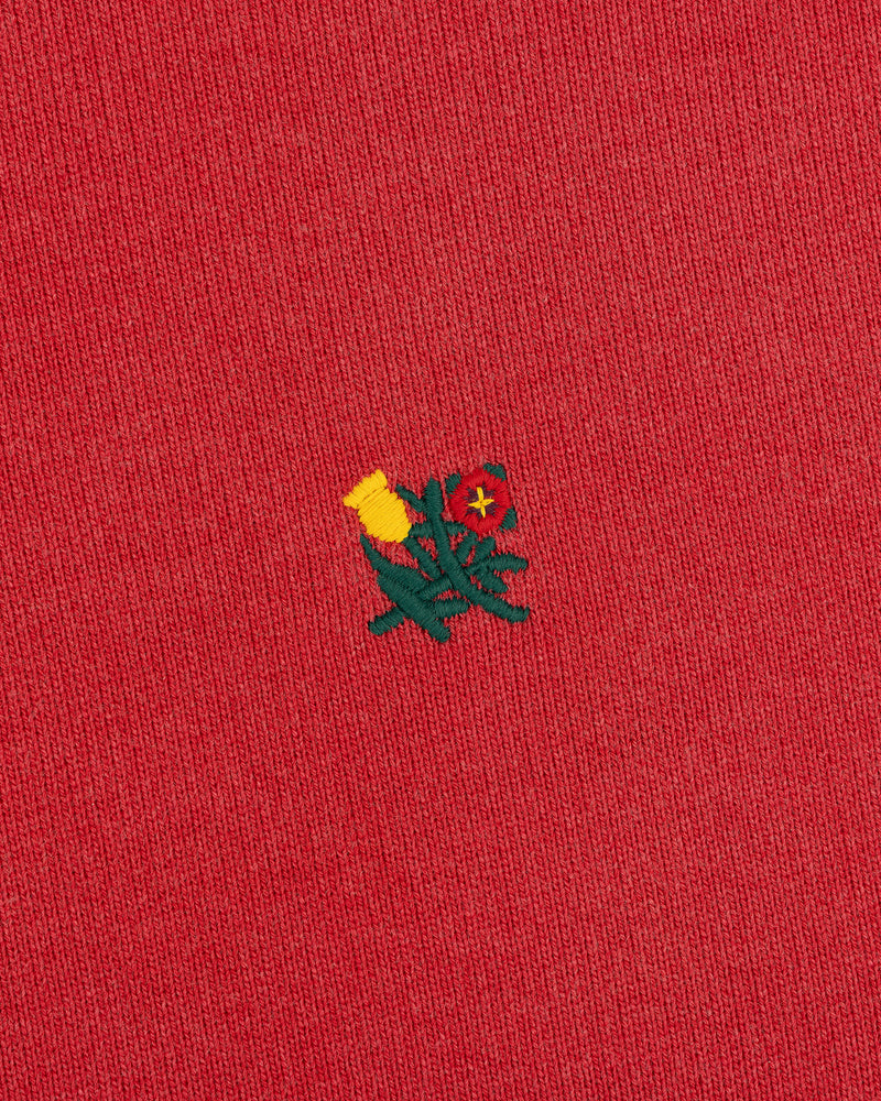 Yellow and red flower embroidery on Sun Faded Crest Quarter Zip's red fabric.