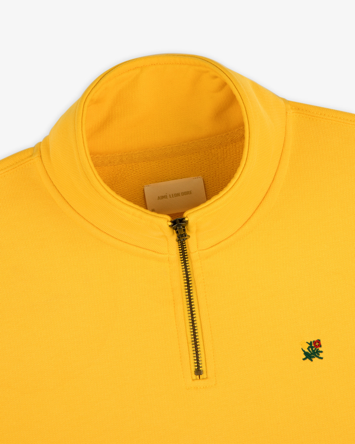 Sun Faded Crest Quarter Zip: bright yellow, small green lion logo, and a visible inner label.