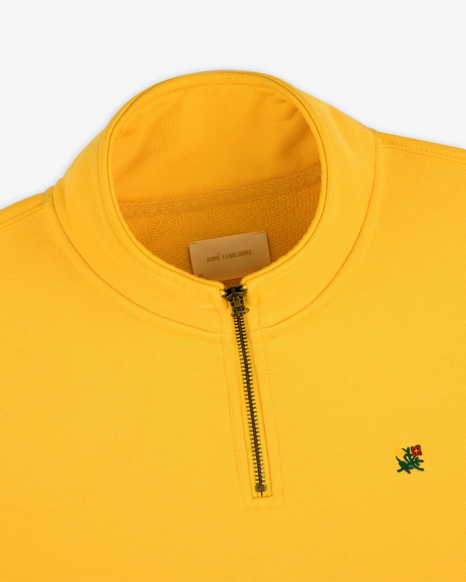 Sun Faded Crest Quarter Zip: bright yellow, small green lion logo, and a visible inner label.