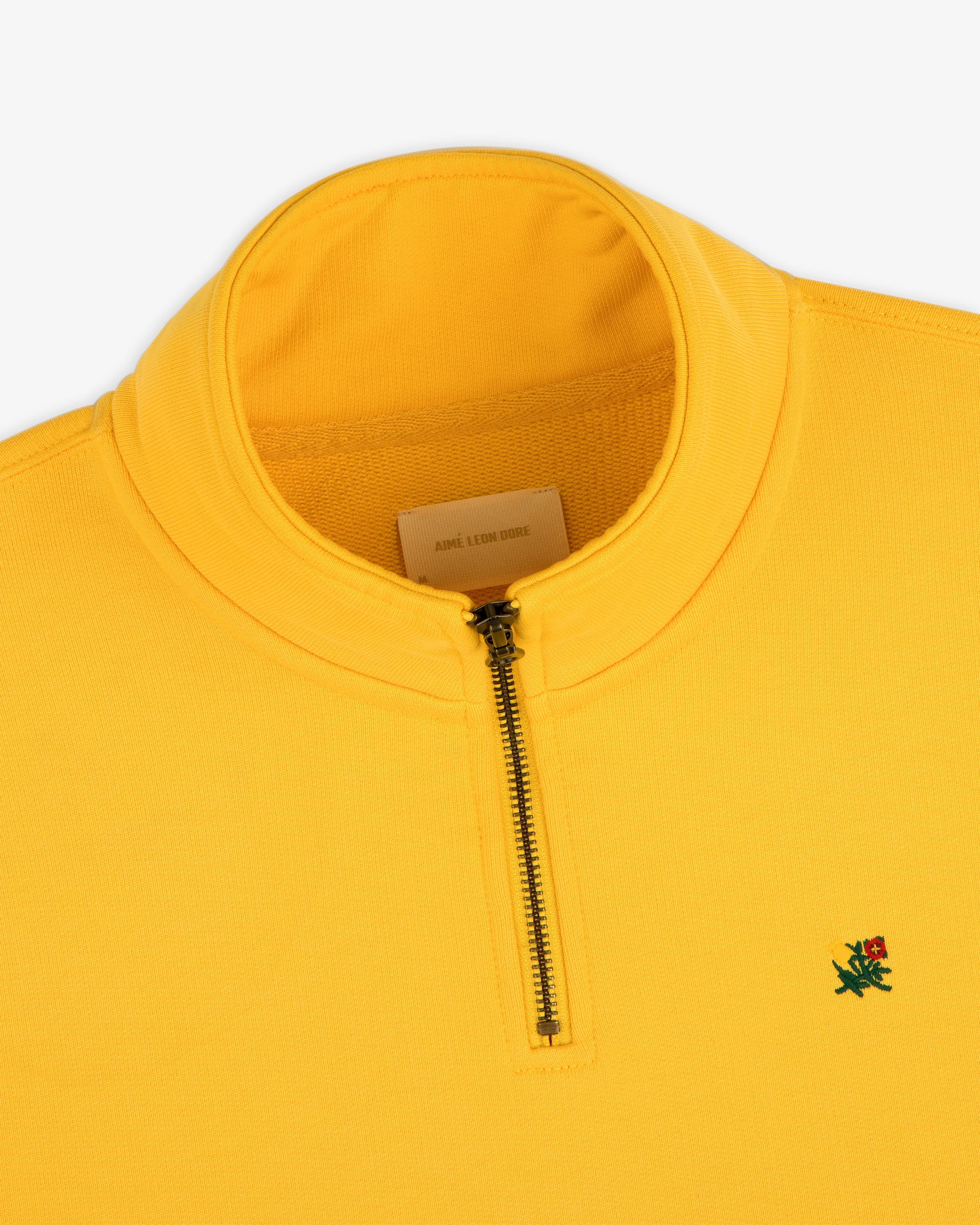 Sun Faded Crest Quarter Zip: bright yellow, small green lion logo, and a visible inner label.