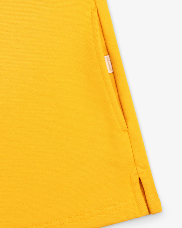 Close-up of the Sun Faded Crest Quarter Zip in yellow with a pocket and small side slit on a white background.