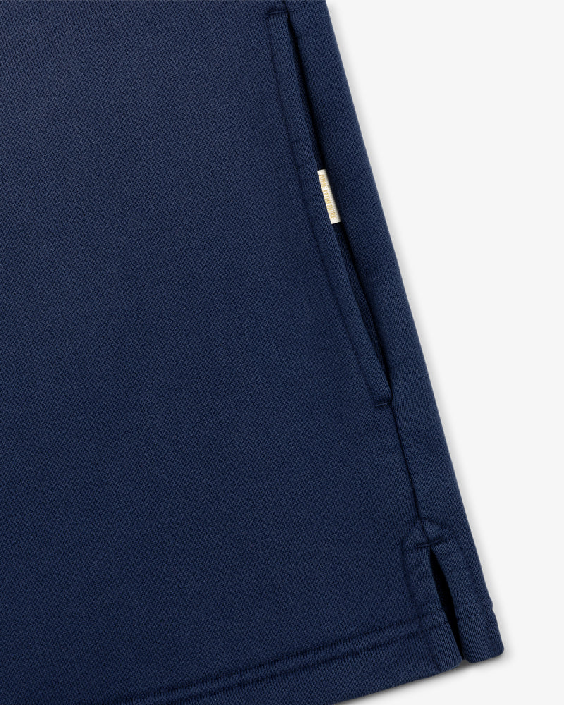 Close-up of the Sun Faded Crest Quarter Zip's navy pocket with a small beige tag and visible edge stitching.