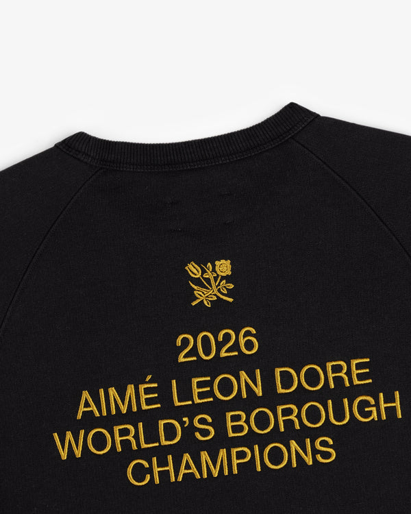 Black ALD / Technics World Champions Crewneck with gold "2026 AIMÉ LEON DORE WORLDS BOROUGH CHAMPIONS" embroidery and floral emblem.