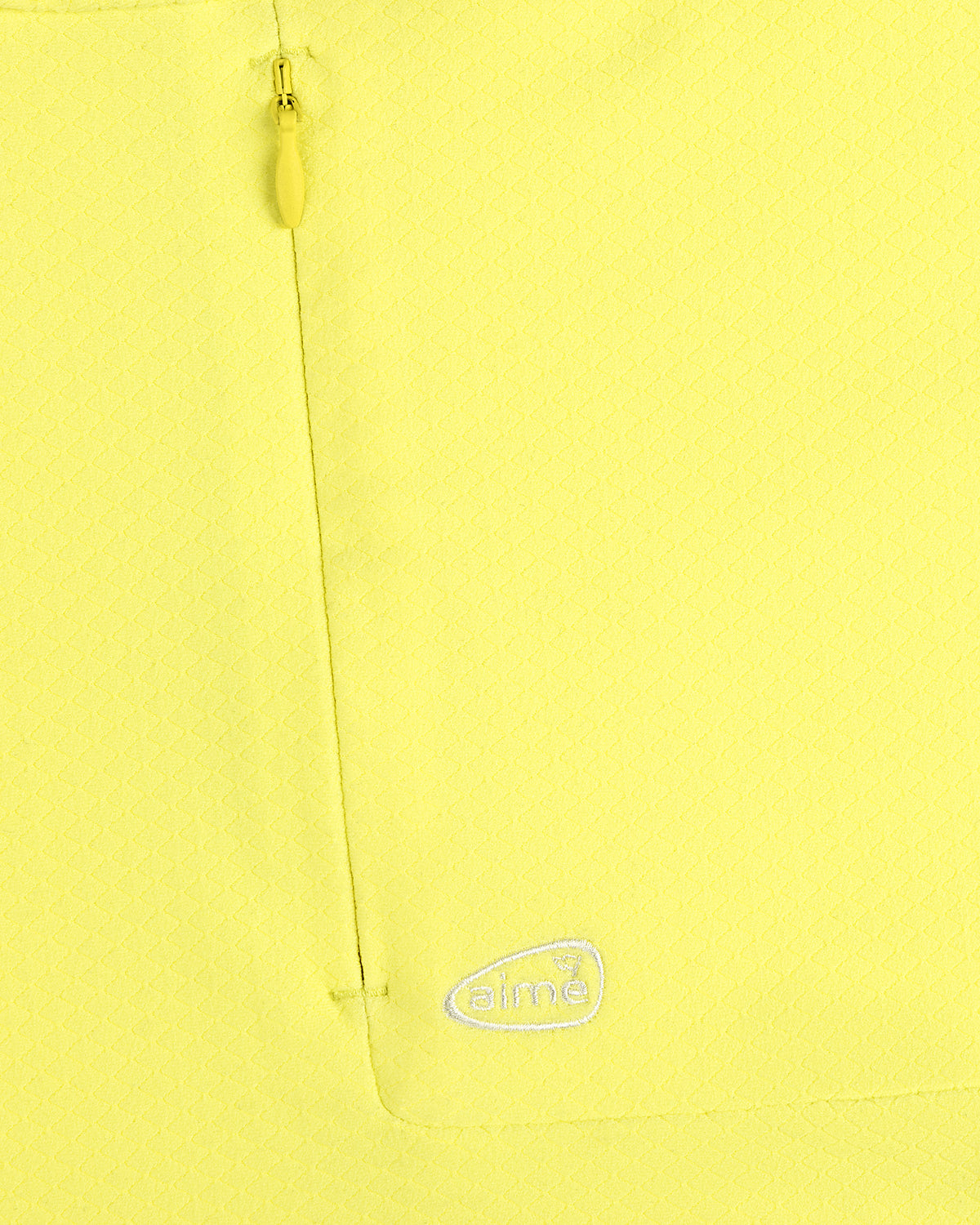 Close-up of ALD Golf Quarter Zip Pullover in yellow with textured fabric, zip pocket, and white aimé logo embroidery.