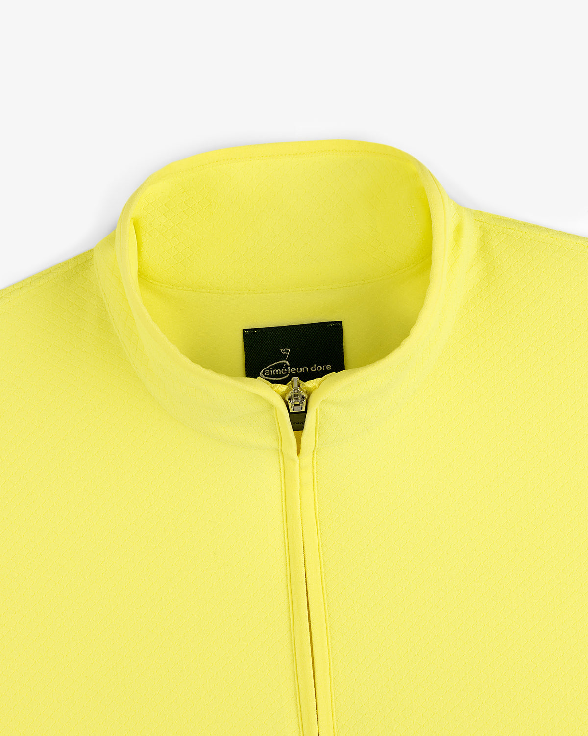 Close-up of a yellow ALD Golf Quarter Zip Pullover with a stand collar and Aimé Leon Dore label inside the neck.