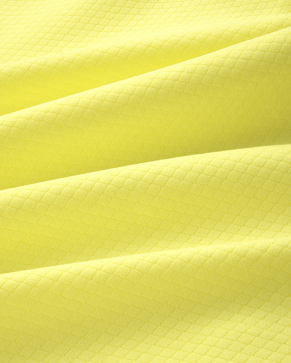 Close-up of yellow ALD Golf Quarter Zip Pullover fabric with a subtle diamond pattern and gentle folds.