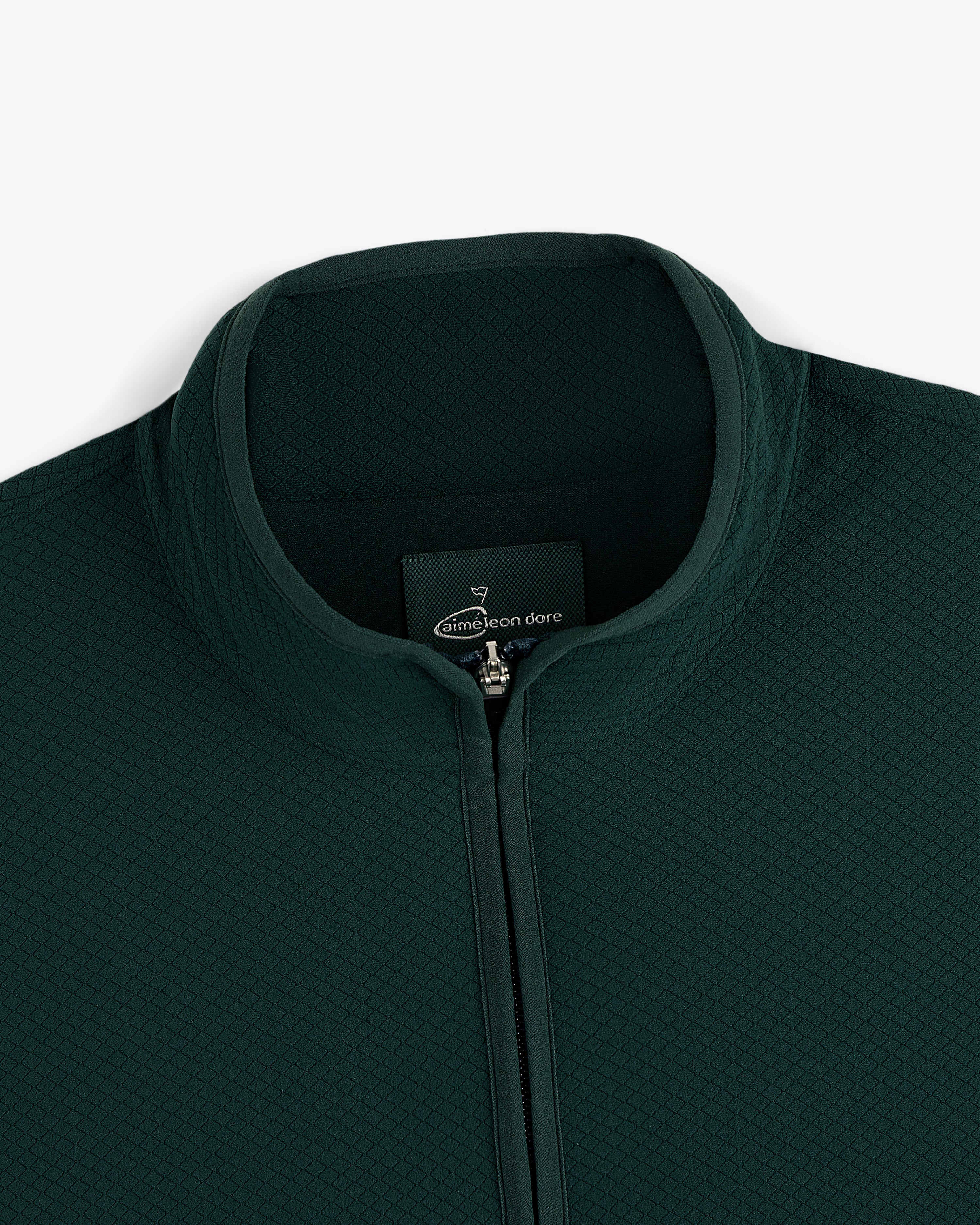 Close-up of the ALD Golf Quarter Zip Pullover in dark green with textured fabric and a stand collar.