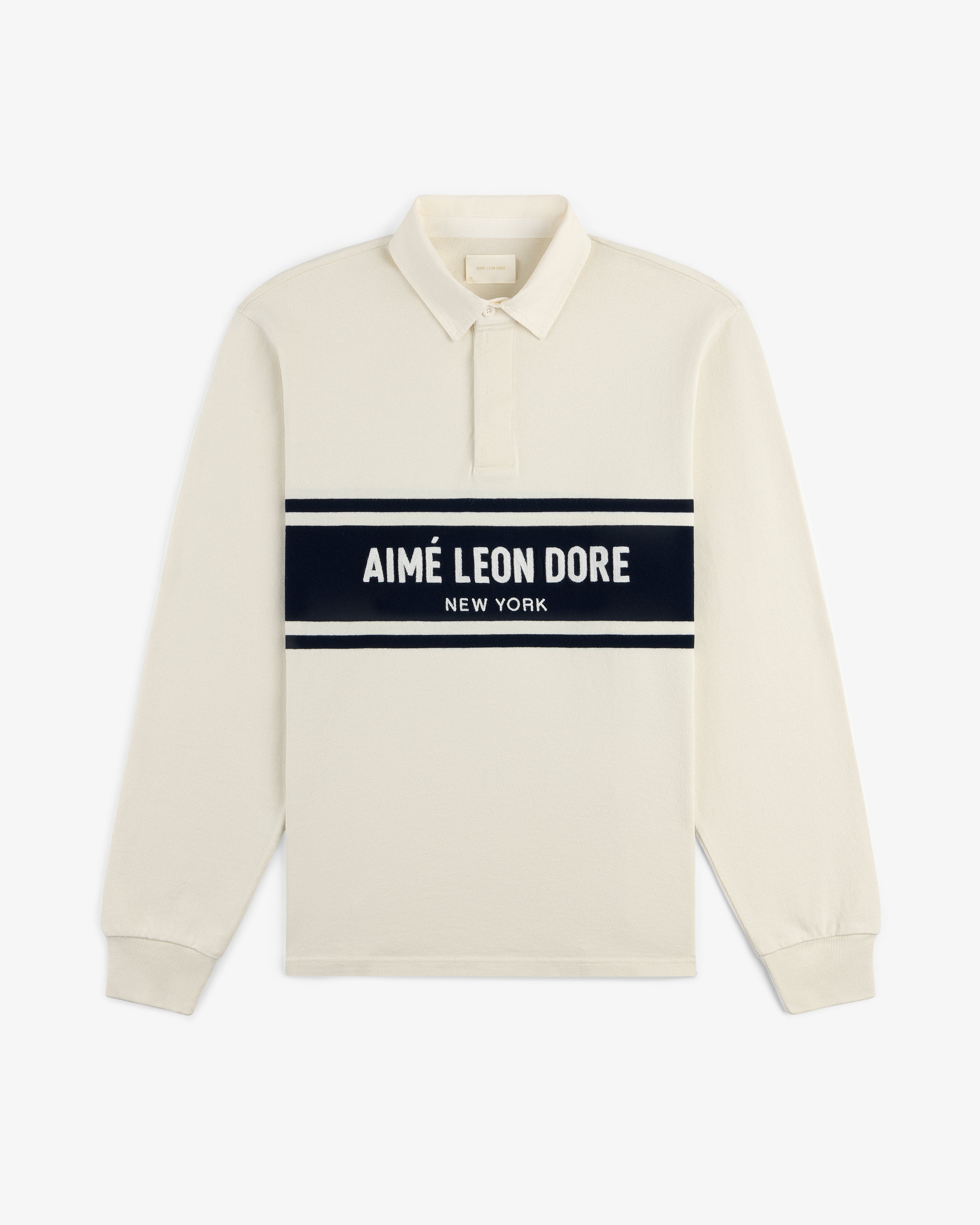 Chest Stripe Logo Rugby: cream long-sleeve polo with AIMÉ LEON DORE NEW YORK on a navy chest stripe.