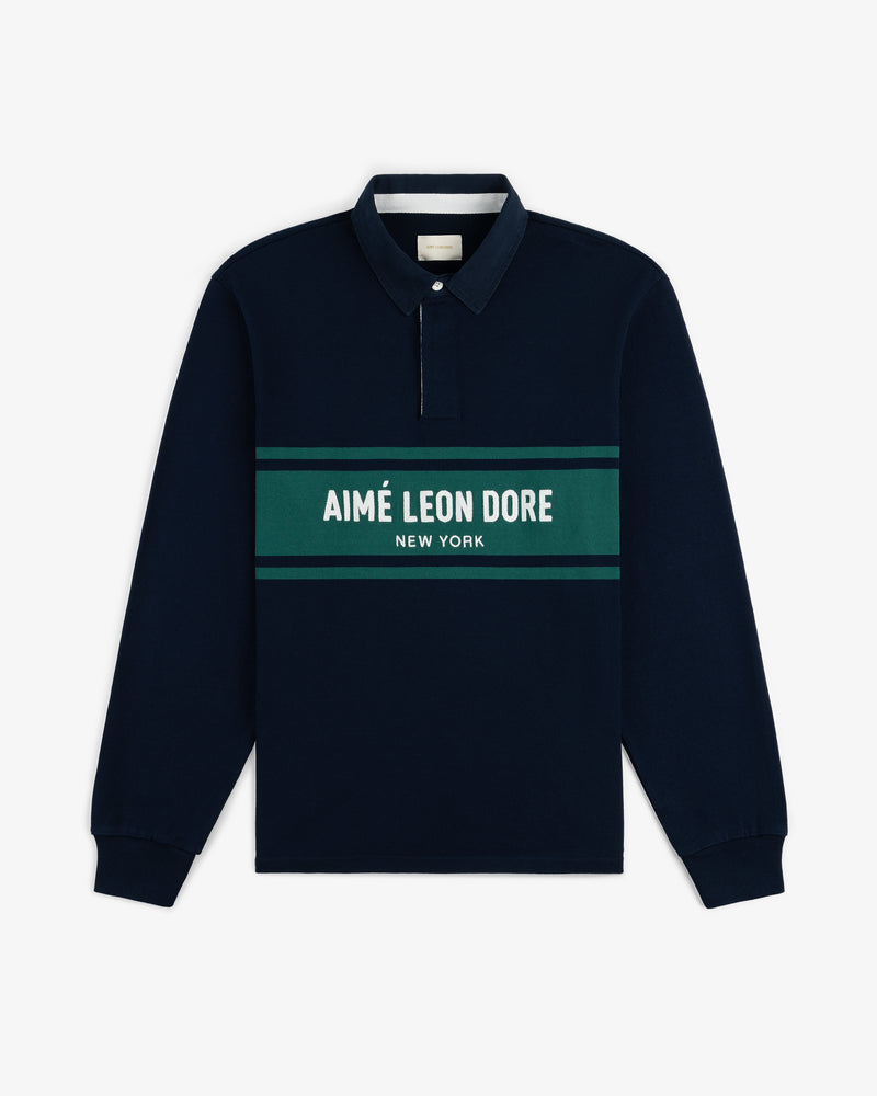 Chest Stripe Logo Rugby in navy with green stripes and AIMÉ LEON DORE NEW YORK text across the chest.