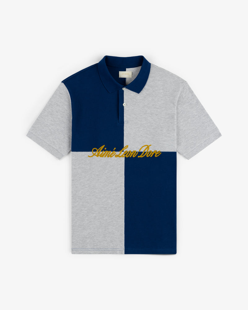 Color Blocked Pique Polo featuring blue and gray panels with gold Aimé Leon Dore script across the chest.