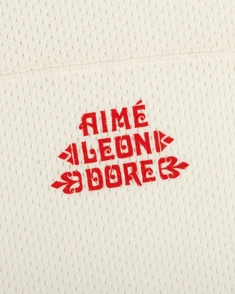 Cream Pointelle Stacked Logo Tee with red AIMÉ LEON DORE text printed in the center.