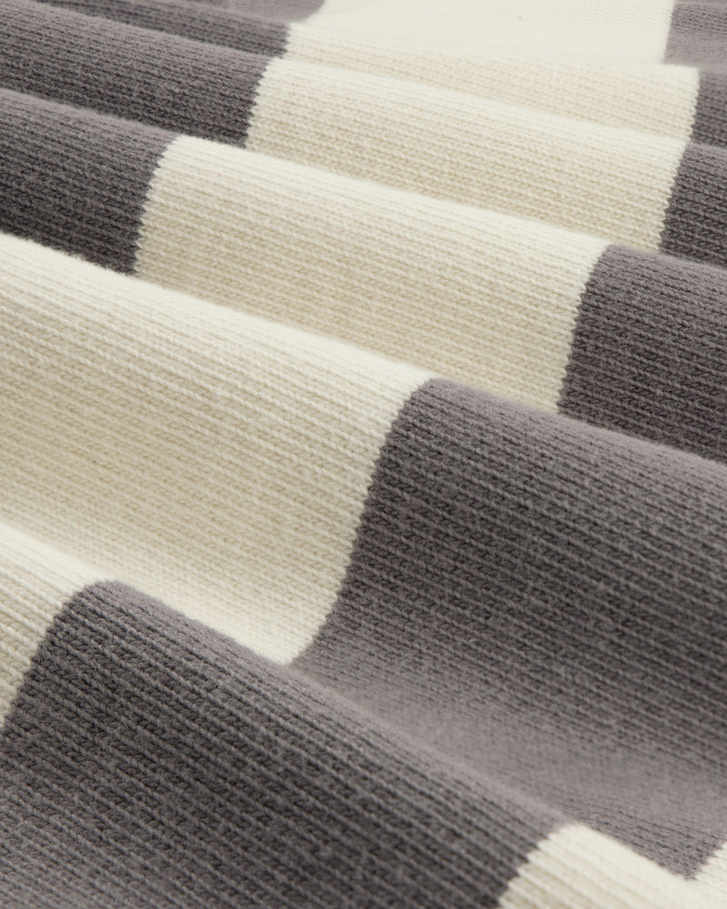 Close-up of Striped Crest Rugby fabric, featuring soft, wavy folds and wide cream and gray horizontal stripes.