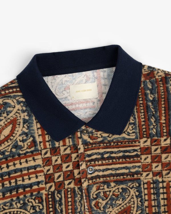 Paisley Printed Piqué Polo with navy collar and tapestry-style red, beige, and blue geometric pattern.