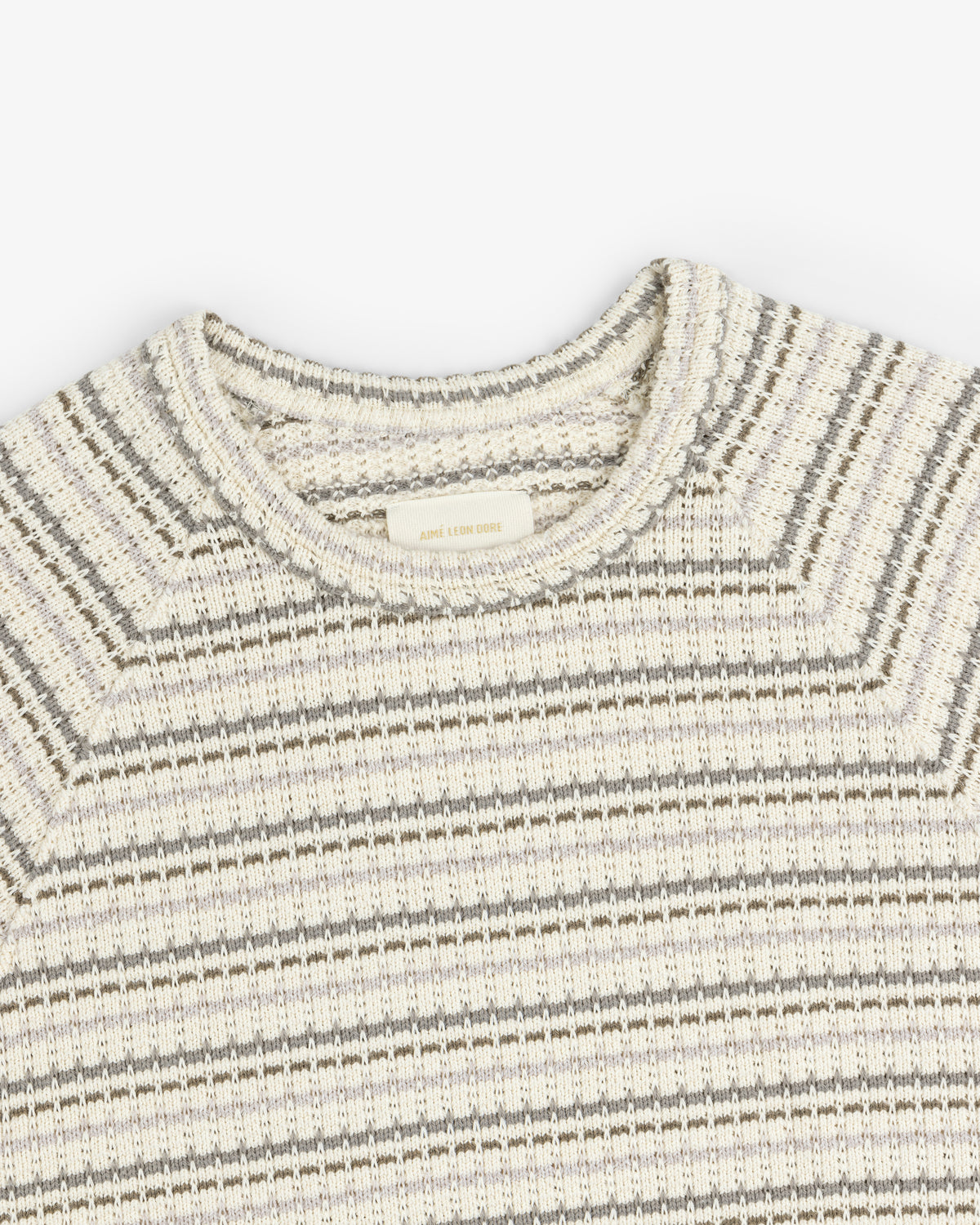 The Jacquard Striped Tee in beige and gray, featuring a round neckline, shown from above on a white background.