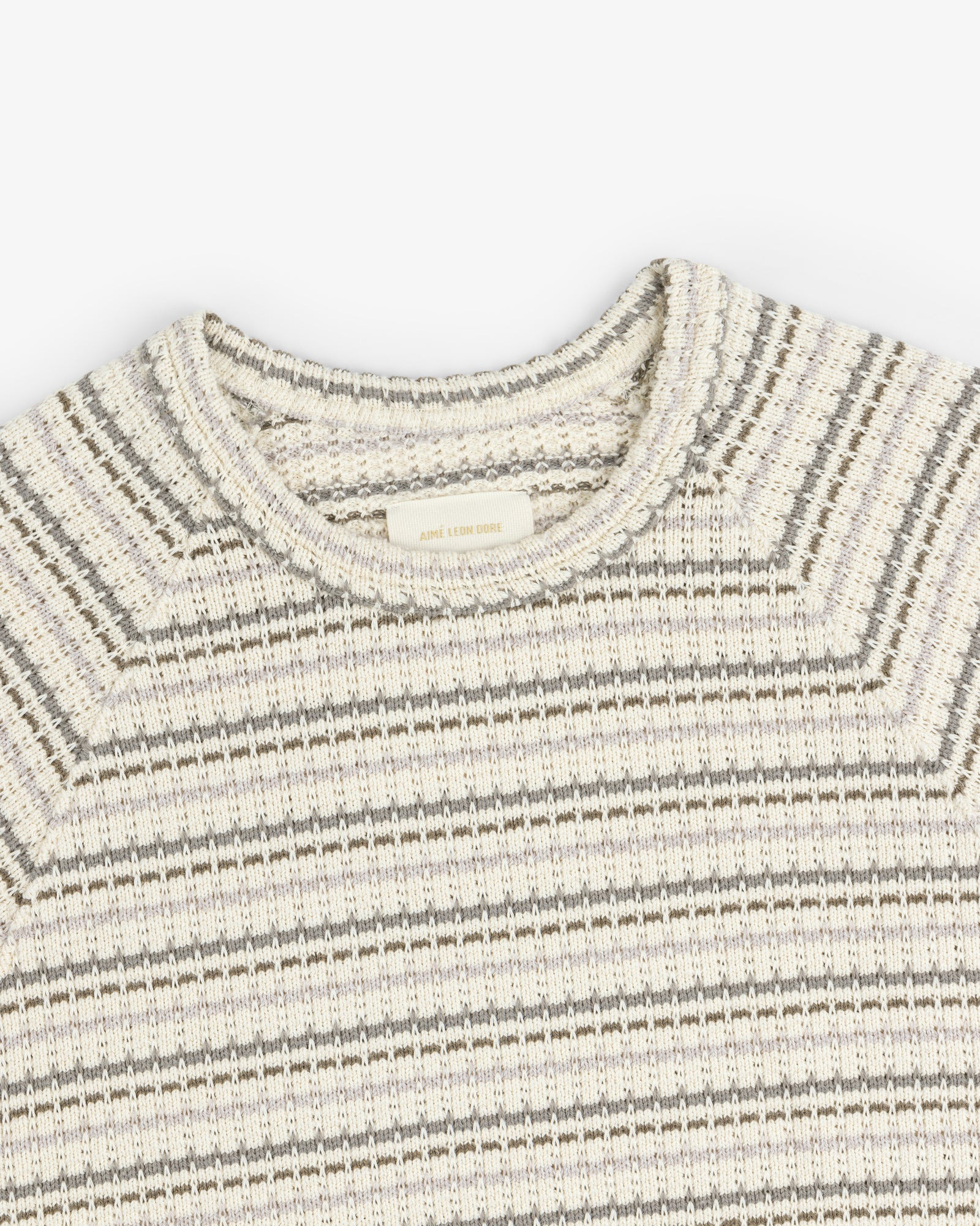 The Jacquard Striped Tee in beige and gray, featuring a round neckline, shown from above on a white background.