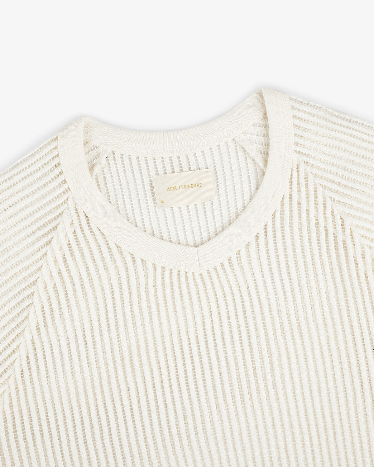 Off-white Mesh V-Neck Tee features textured fabric and a beige label inside the collar.