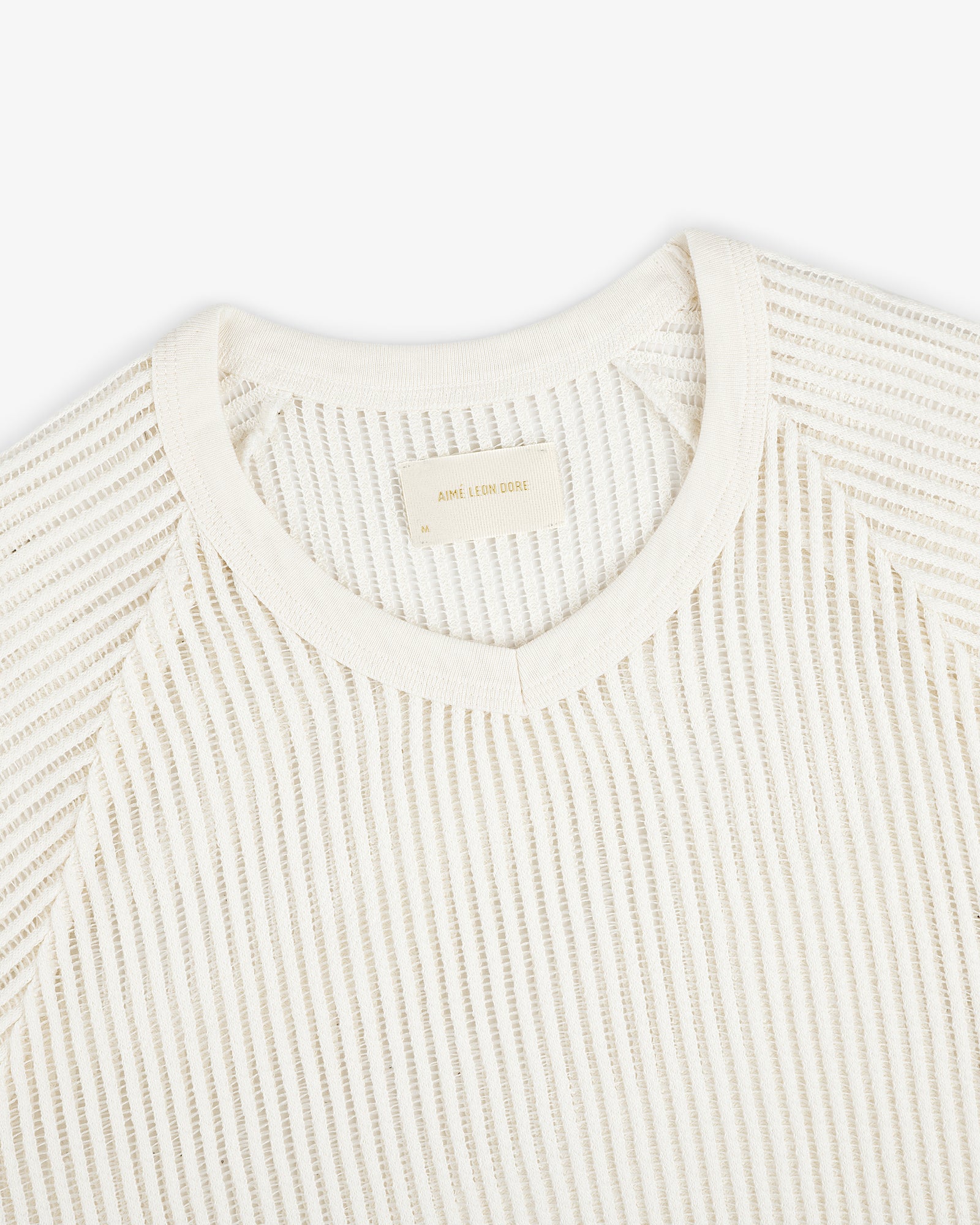 Off-white Mesh V-Neck Tee features textured fabric and a beige label inside the collar.