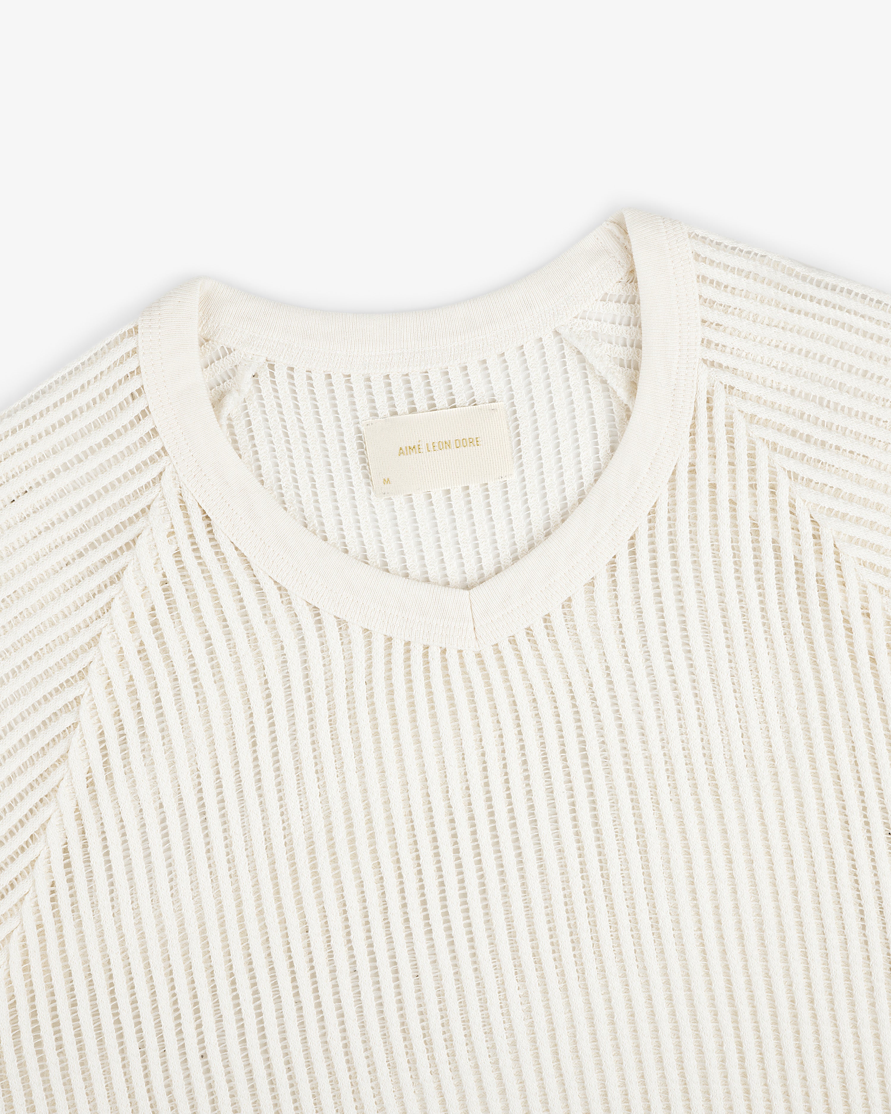Off-white Mesh V-Neck Tee features textured fabric and a beige label inside the collar.