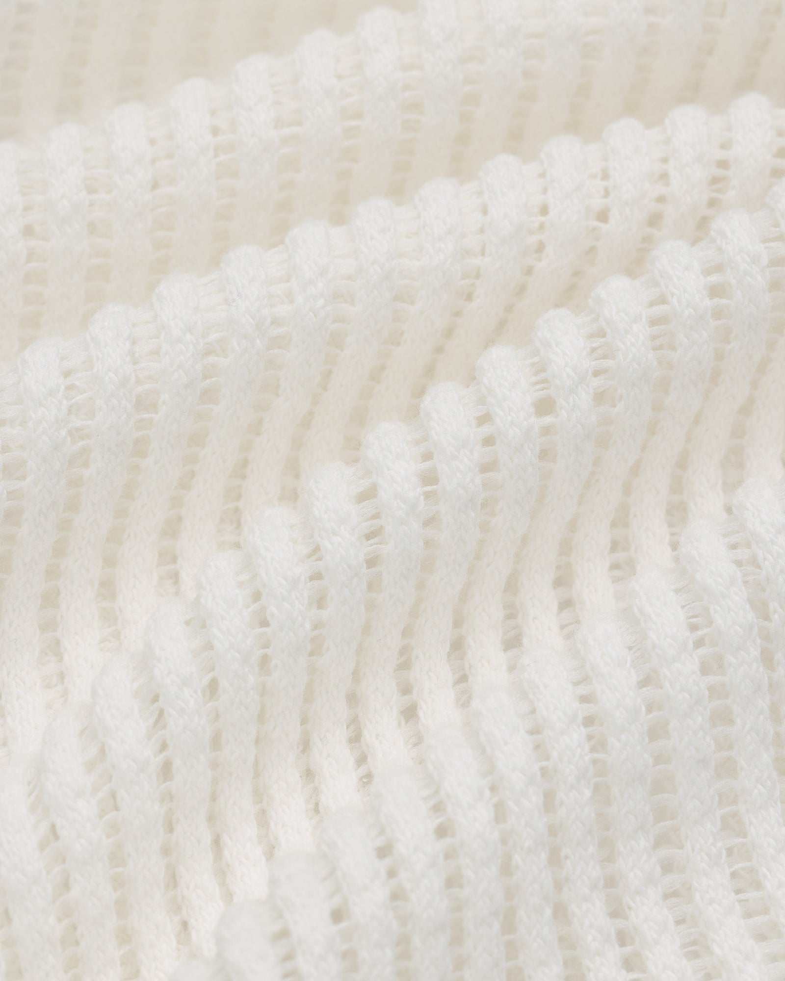 Close-up of the white Mesh V-Neck Tee showing its ribbed, textured fabric with evenly spaced horizontal ridges.