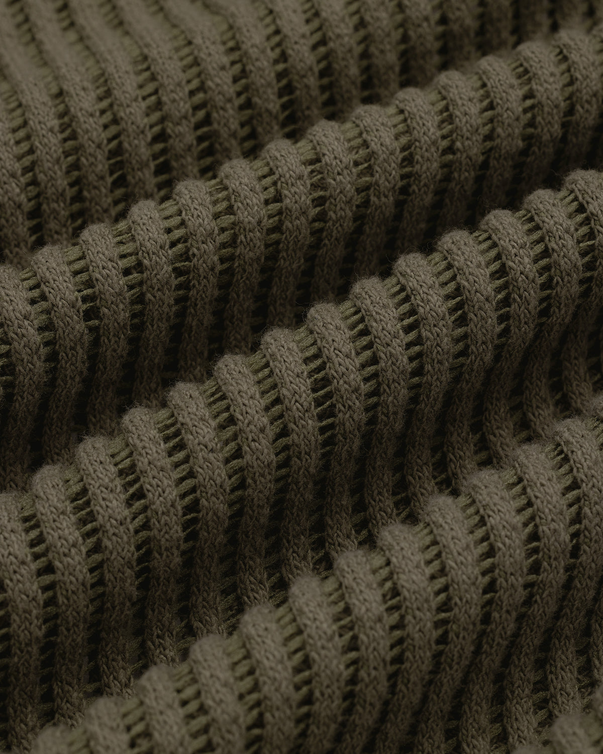 Close-up of textured, ribbed olive green knit fabric from the Mesh V-Neck Tee, featuring horizontal ridges.