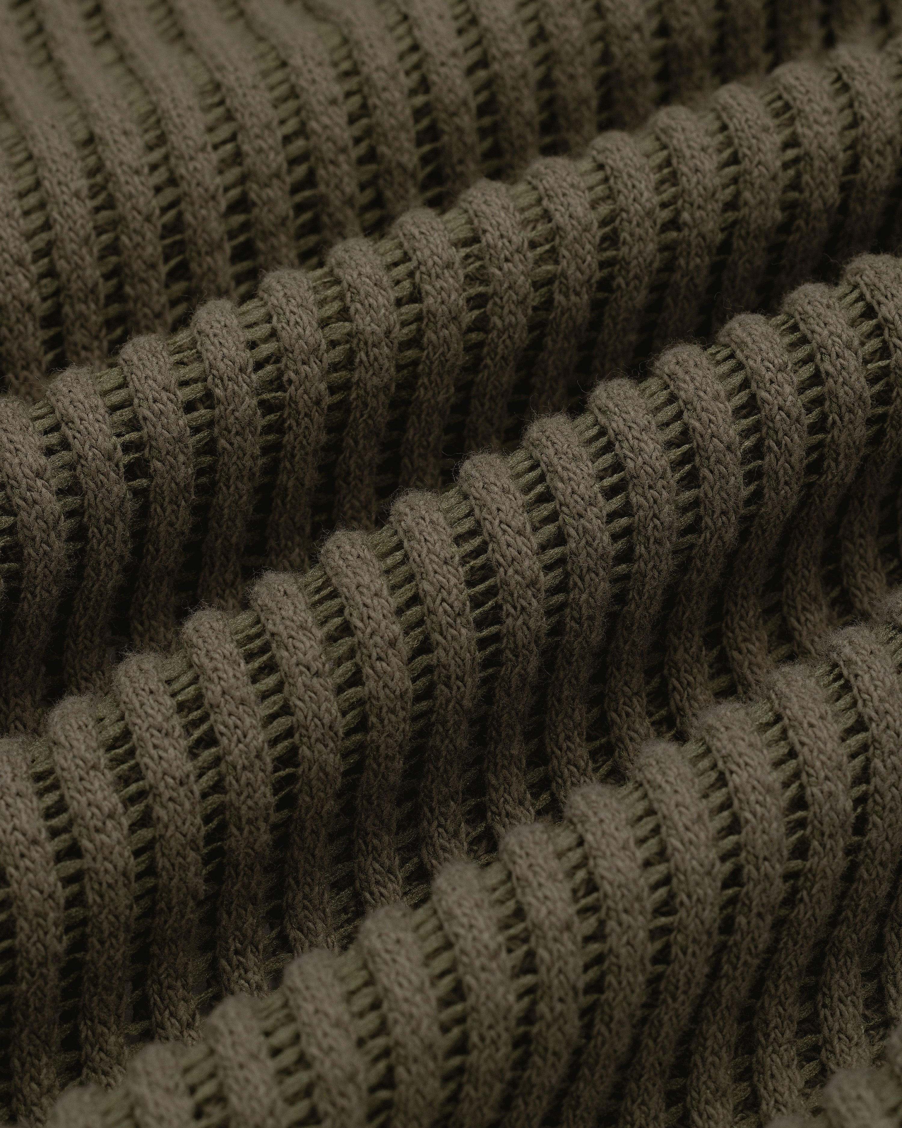 Close-up of textured, ribbed olive green knit fabric from the Mesh V-Neck Tee, featuring horizontal ridges.