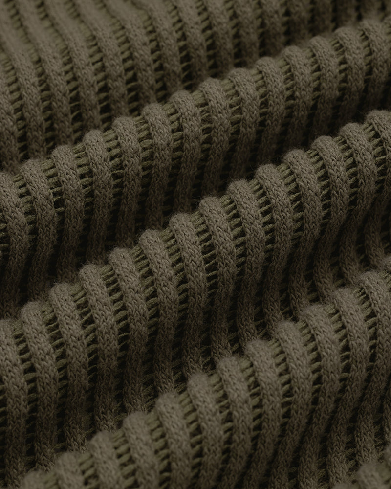 Close-up of textured, ribbed olive green knit fabric from the Mesh V-Neck Tee, featuring horizontal ridges.