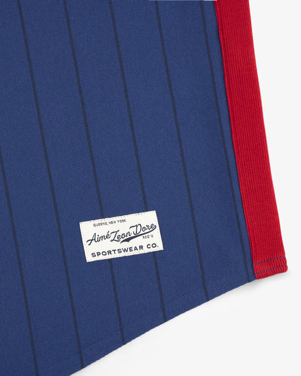 Blue Aimé Baseball Jersey with thin vertical stripes, red trim, and a white Aimé Leon Dore Sportswear Co. label at hem.