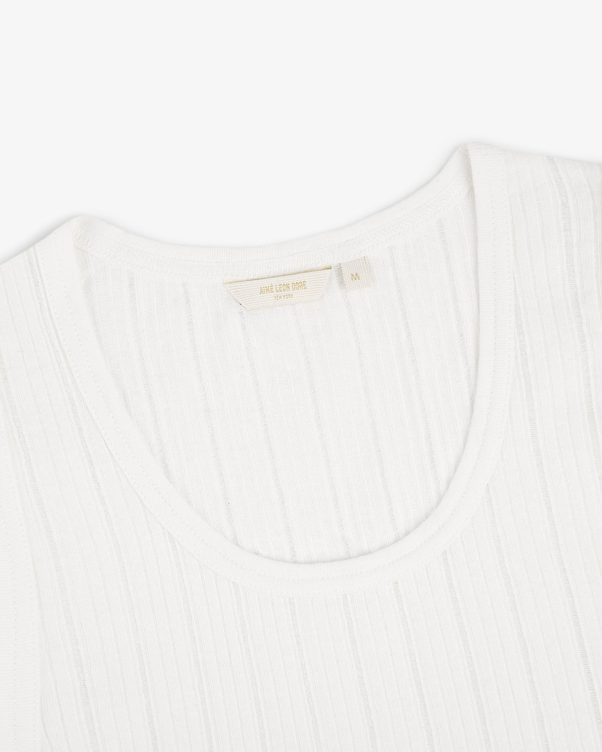 Close-up of a white Drop Needle Tank Top with a ribbed crew neck and visible tag on a plain white background.