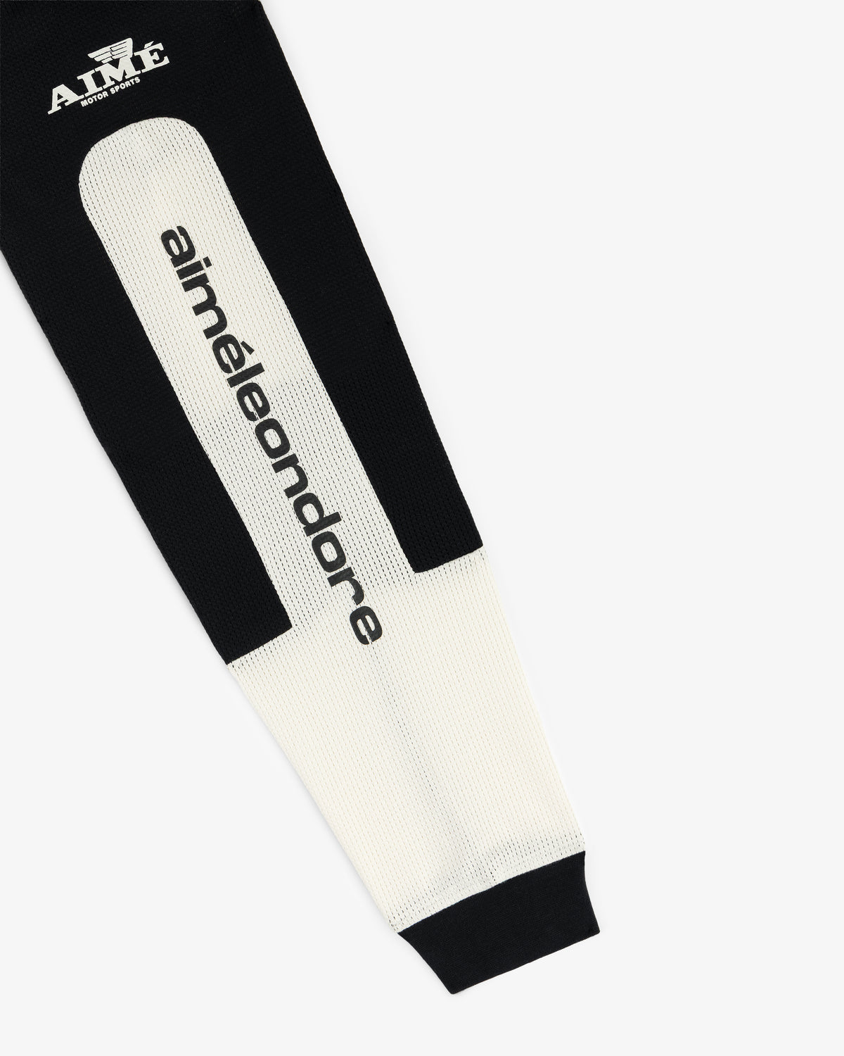 The Long-Sleeve Mesh Enduro Tee is a black and white knit with “aiméleondore” and “AIMÉ” logos on the fabric.
