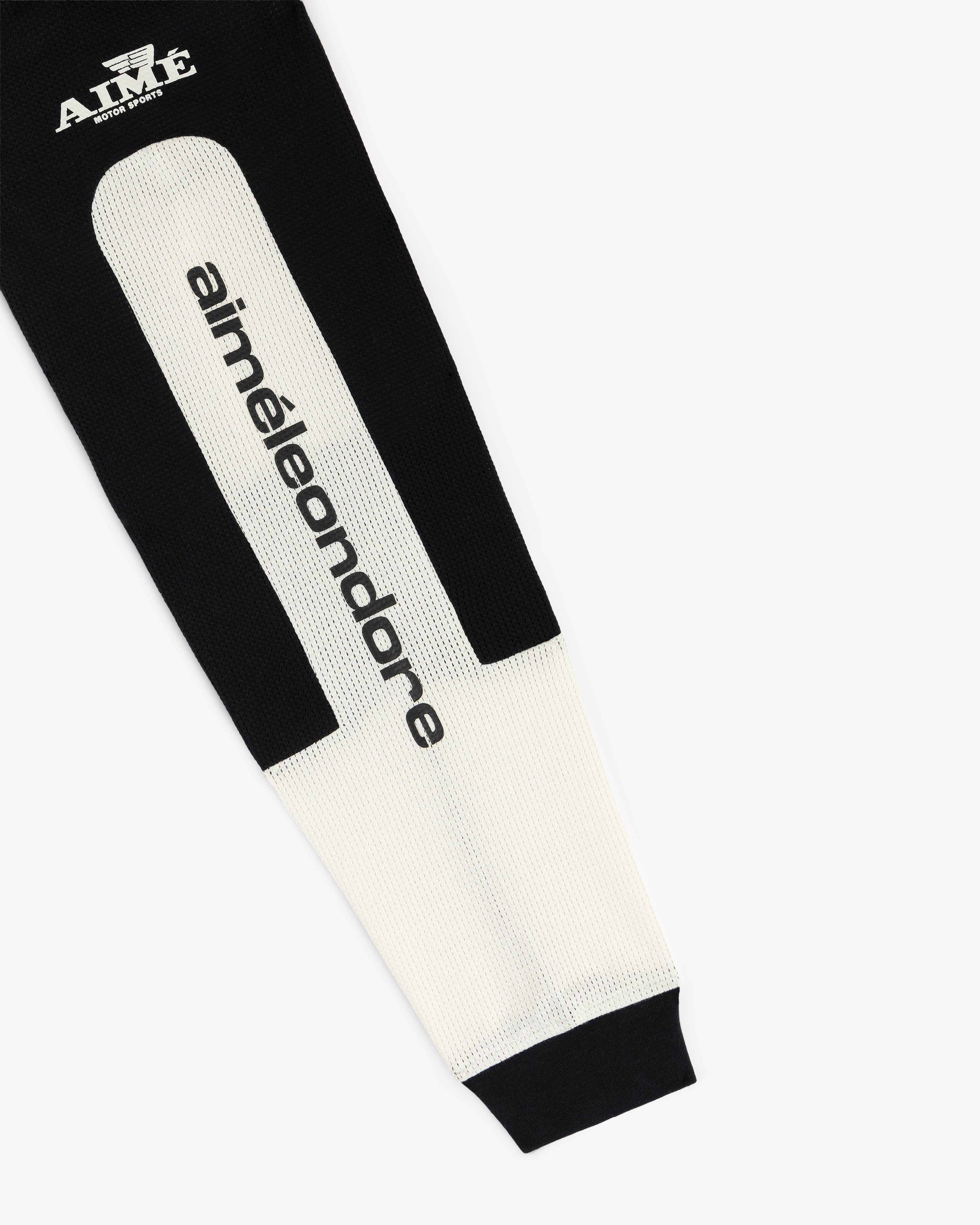 The Long-Sleeve Mesh Enduro Tee is a black and white knit with “aiméleondore” and “AIMÉ” logos on the fabric.