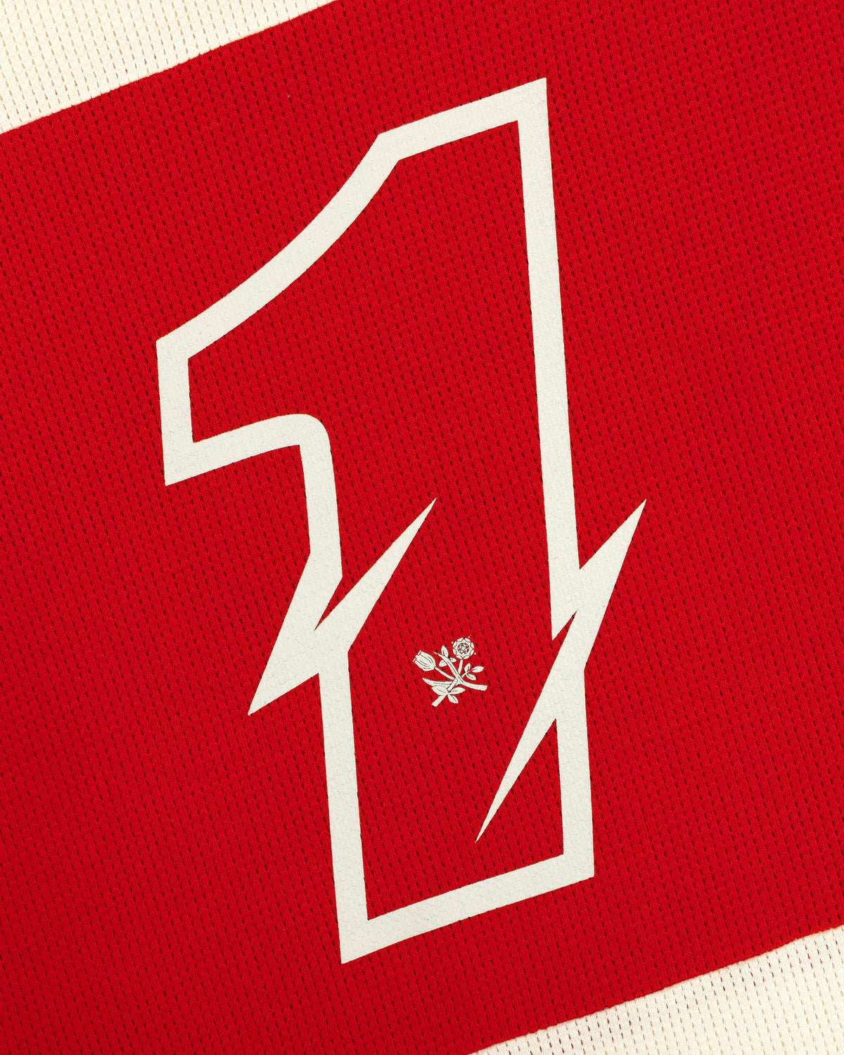 A large white number 1 with a lightning bolt and rose on red fabric of the Long-Sleeve Mesh Enduro Tee.