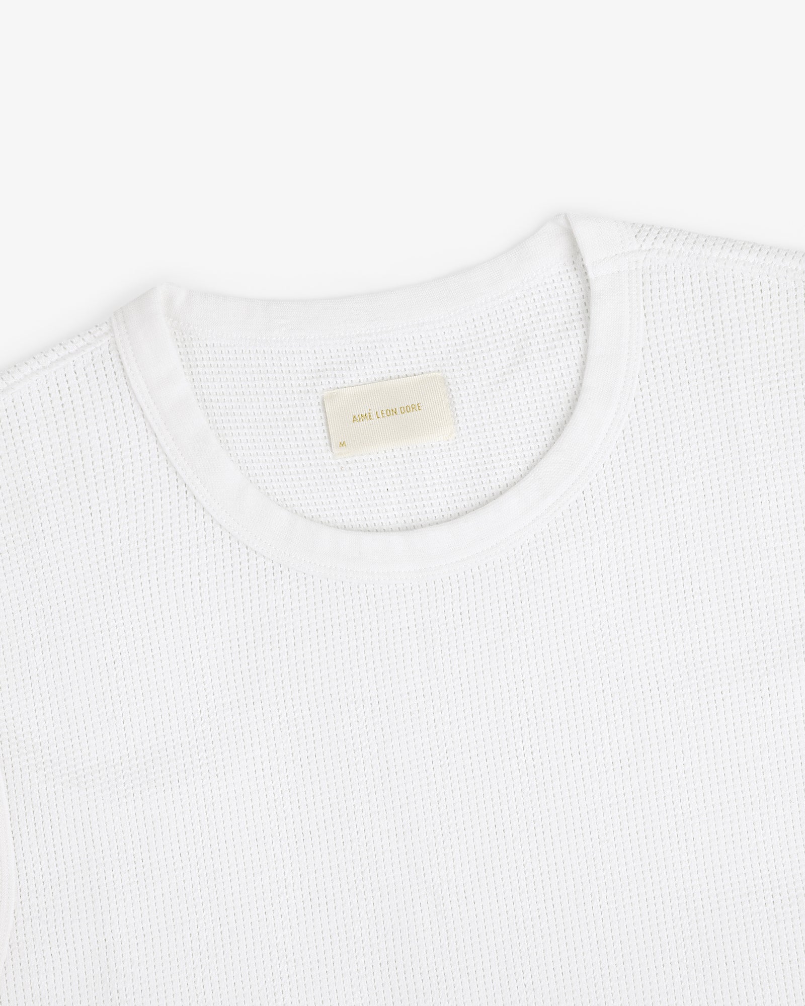 Mesh Muscle Tank shown on a white background with a beige label sewn inside the collar.