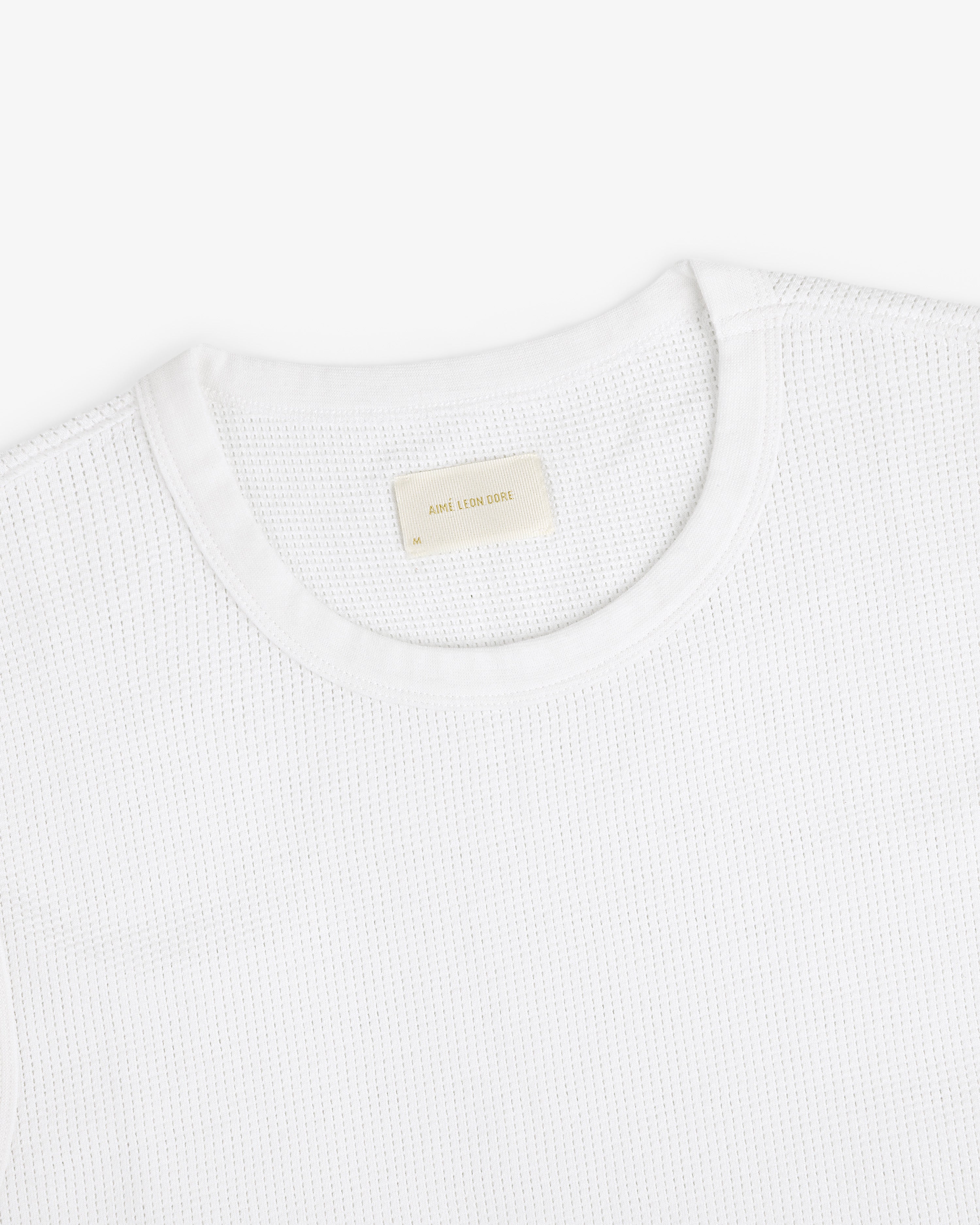 Mesh Muscle Tank shown on a white background with a beige label sewn inside the collar.