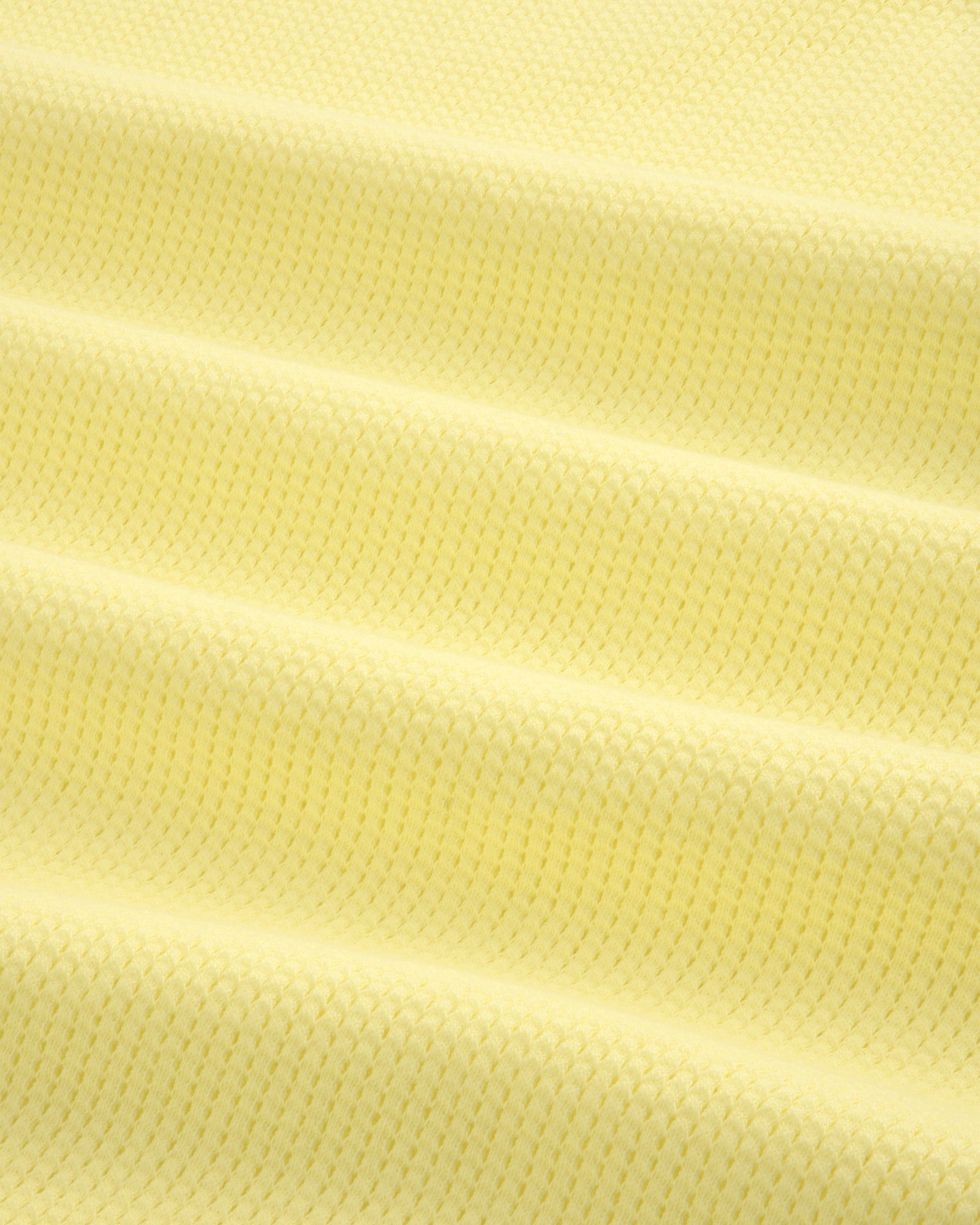 Close-up of pale yellow Mesh Muscle Tank fabric featuring evenly spaced horizontal raised ridges.