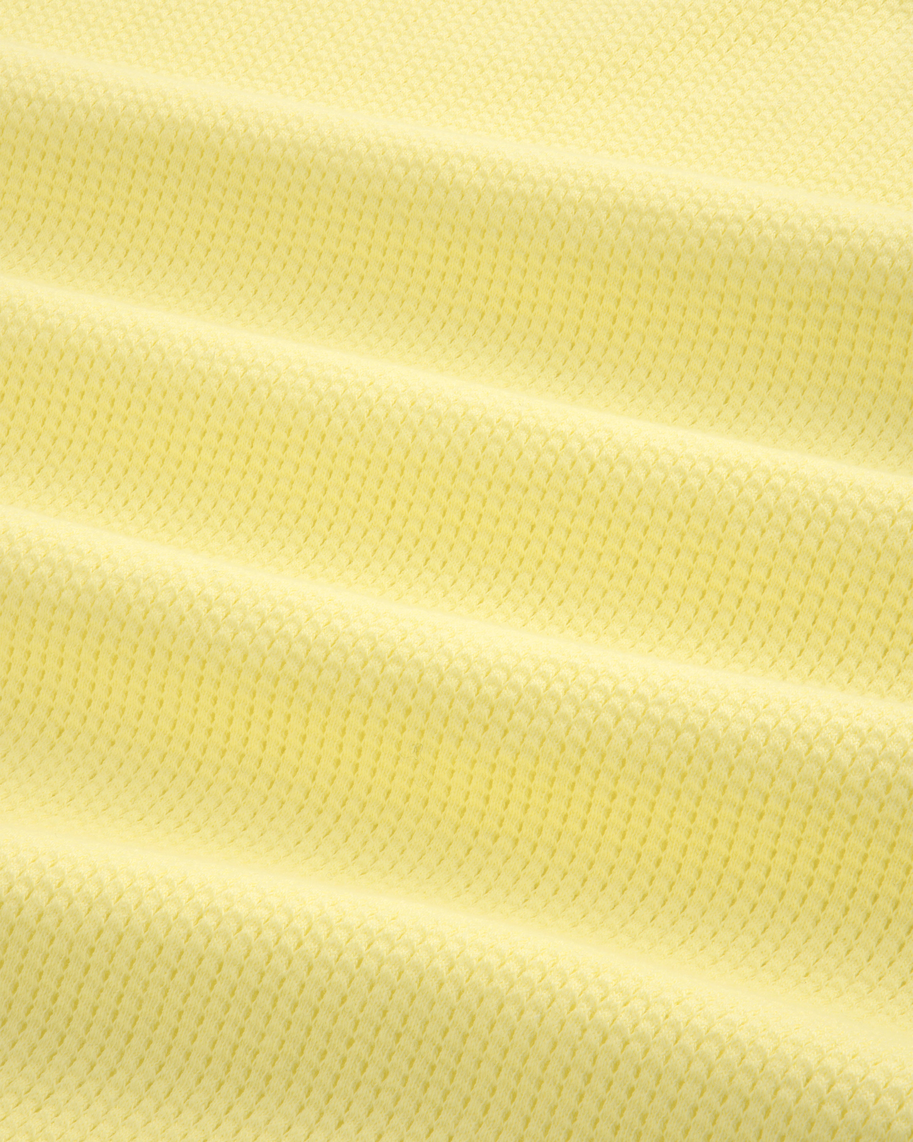 Close-up of pale yellow Mesh Muscle Tank fabric featuring evenly spaced horizontal raised ridges.