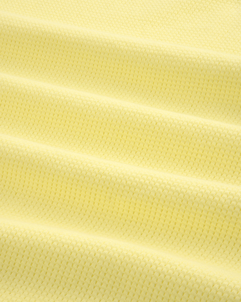 Close-up of pale yellow Mesh Muscle Tank fabric featuring evenly spaced horizontal raised ridges.