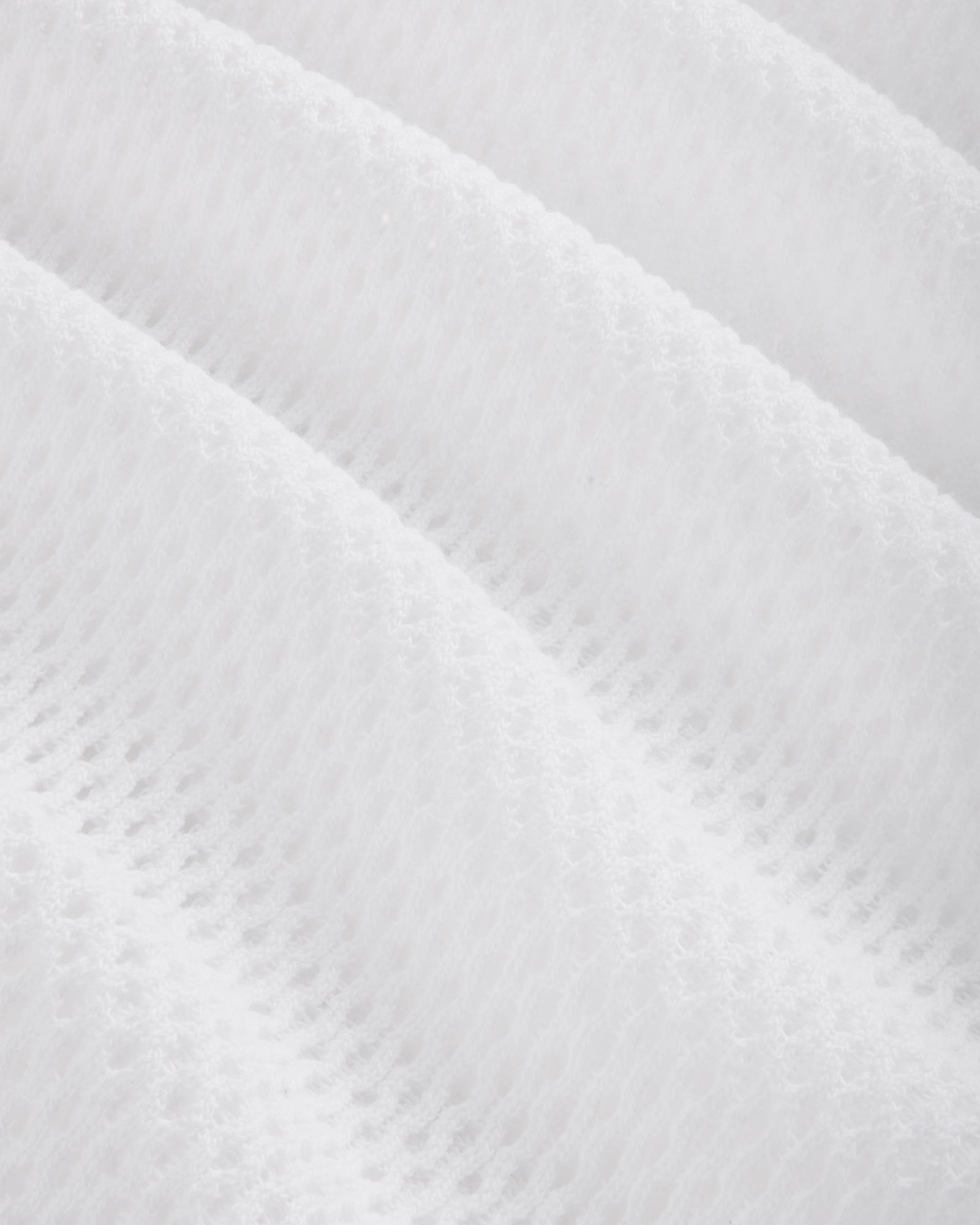 Close-up of the Mesh Tank Top's white fabric featuring a soft, mesh pattern with diagonal ridges.