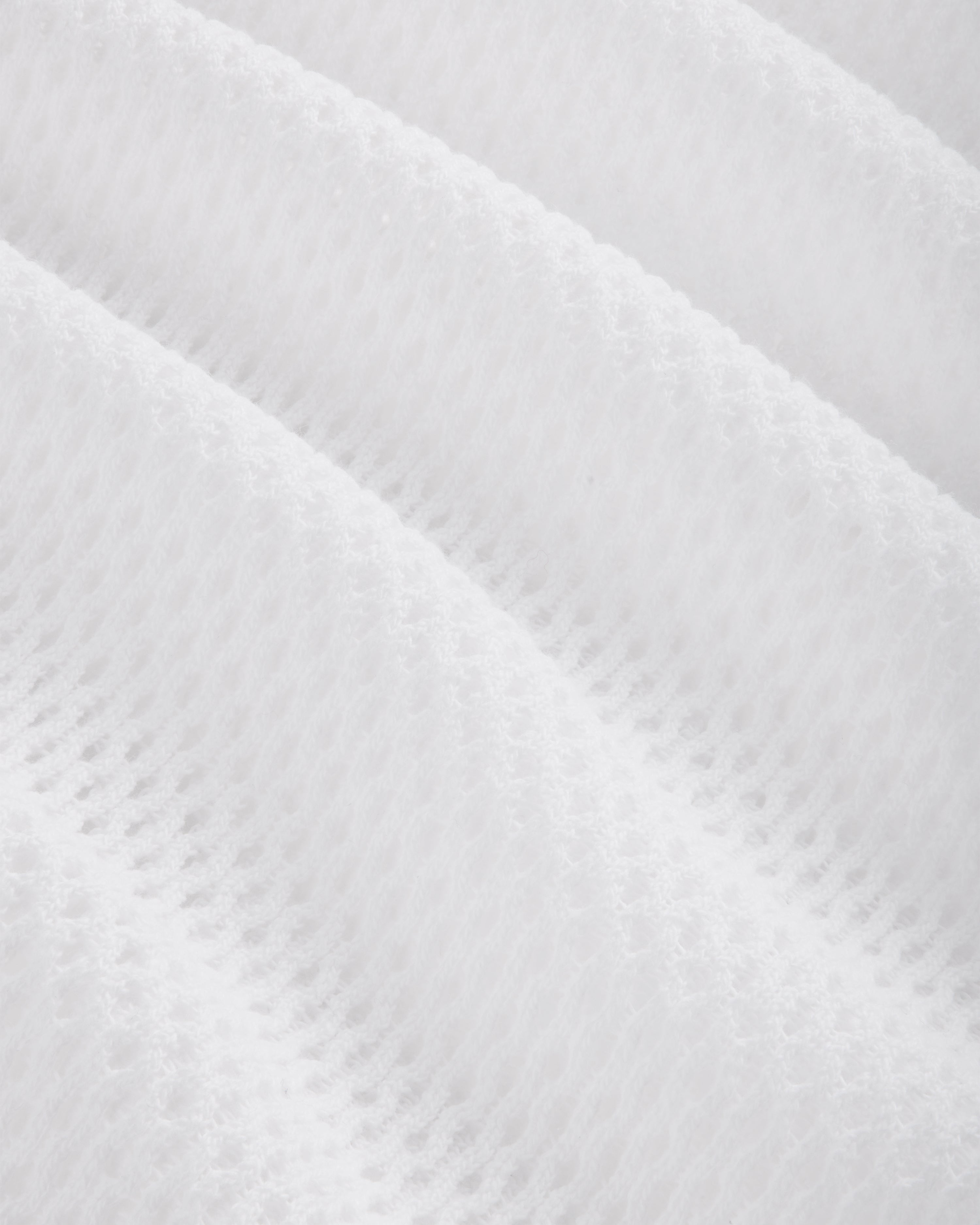 Close-up of the Mesh Tank Top's white fabric featuring a soft, mesh pattern with diagonal ridges.