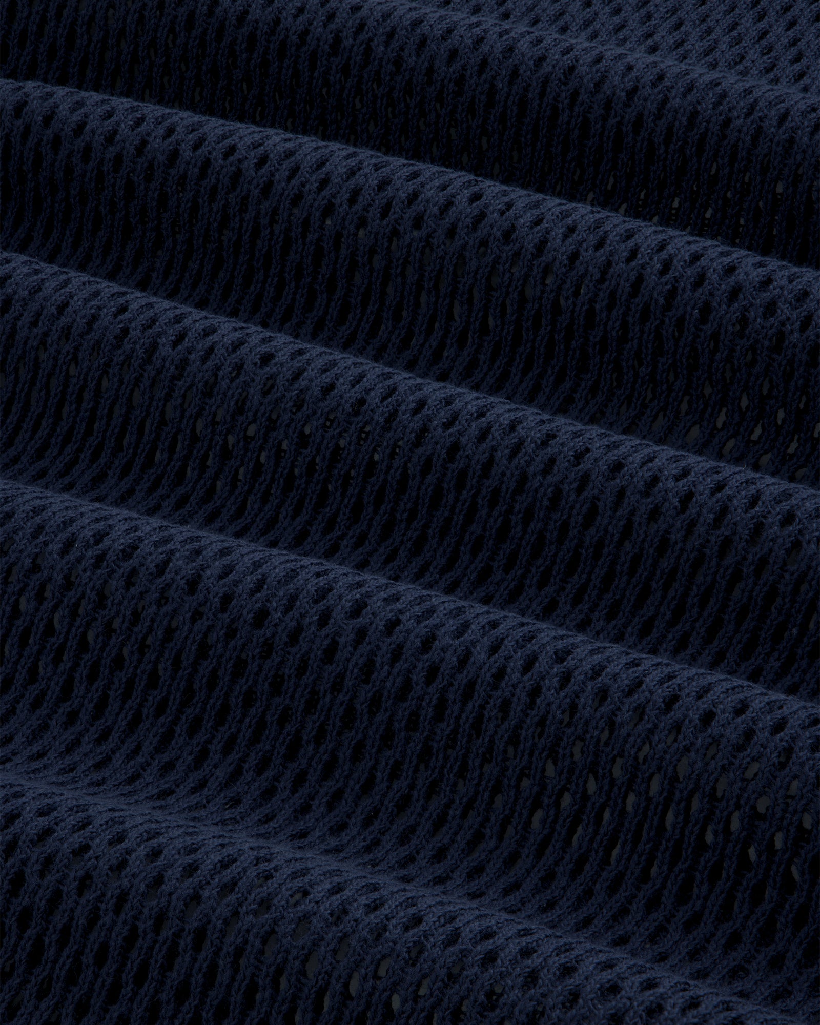 Close-up of the Mesh Tank Top's dark blue, textured mesh fabric with evenly spaced holes and soft folds.