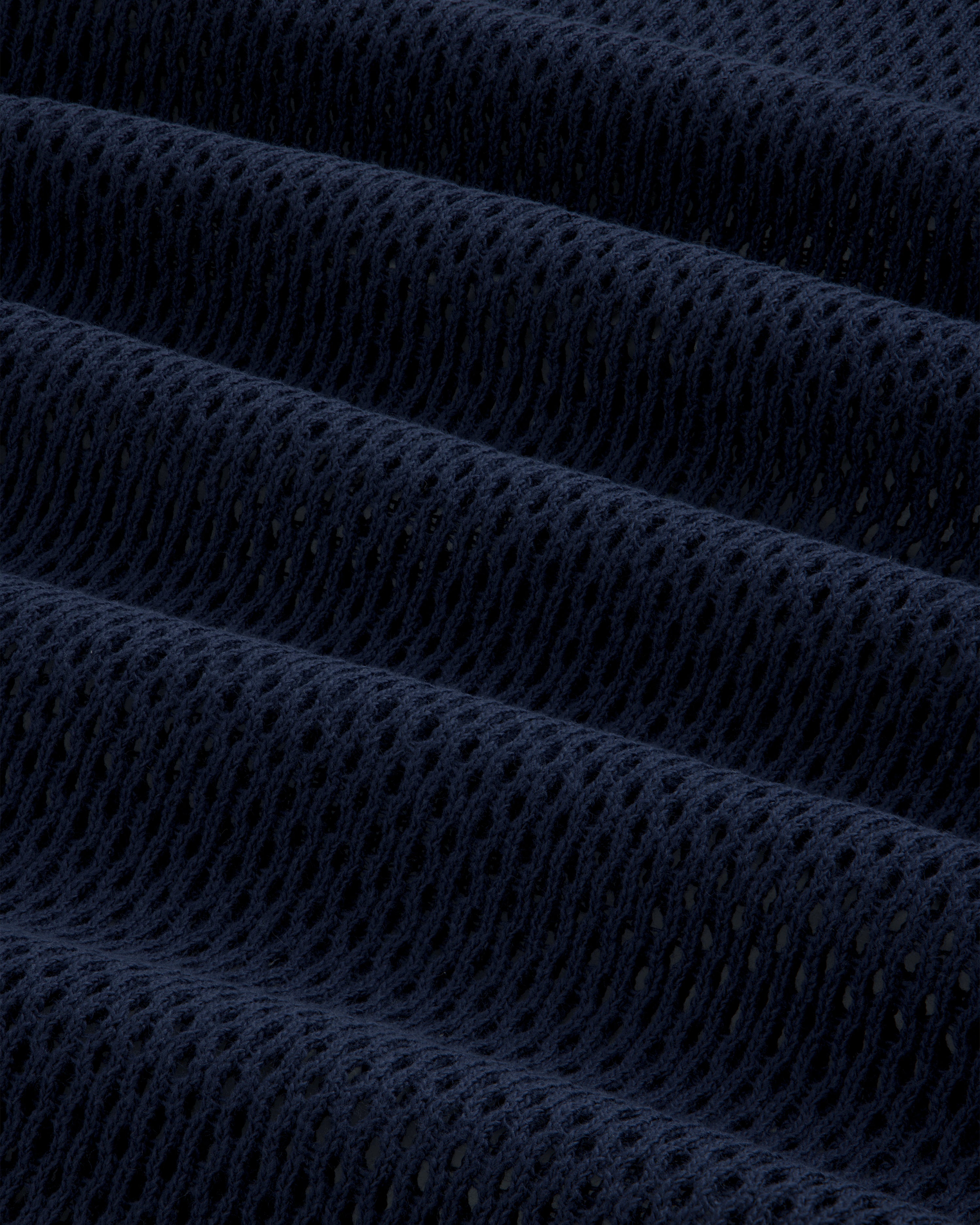 Close-up of the Mesh Tank Top's dark blue, textured mesh fabric with evenly spaced holes and soft folds.