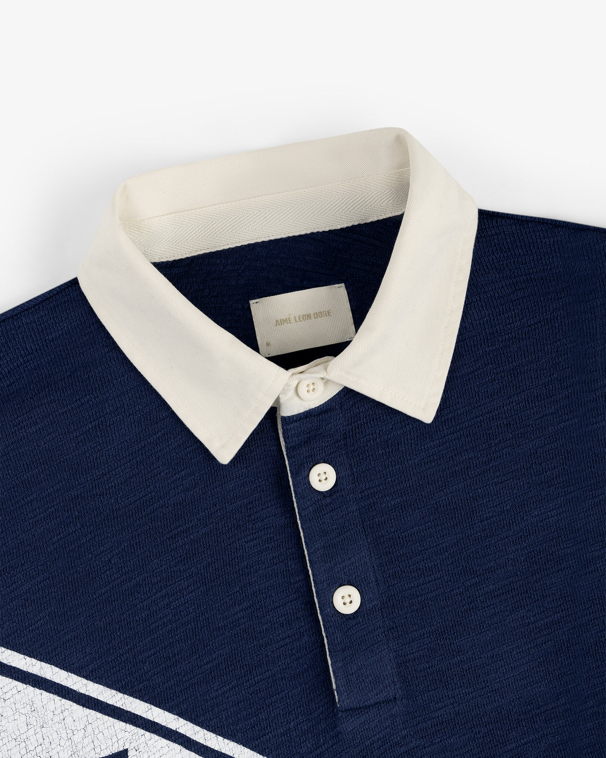 Vintage Slub Rugby in navy blue with white buttons and a white collar, flat laid on a white background.