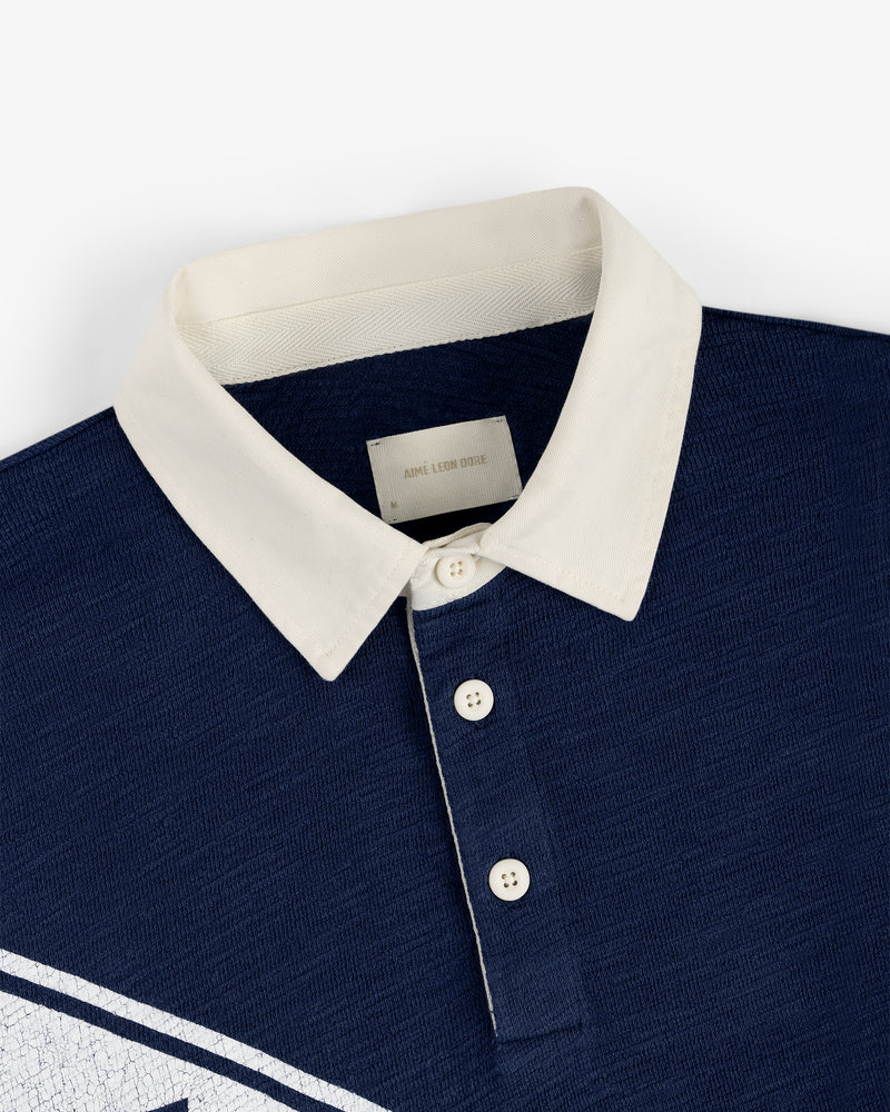 Vintage Slub Rugby in navy blue with white buttons and a white collar, flat laid on a white background.
